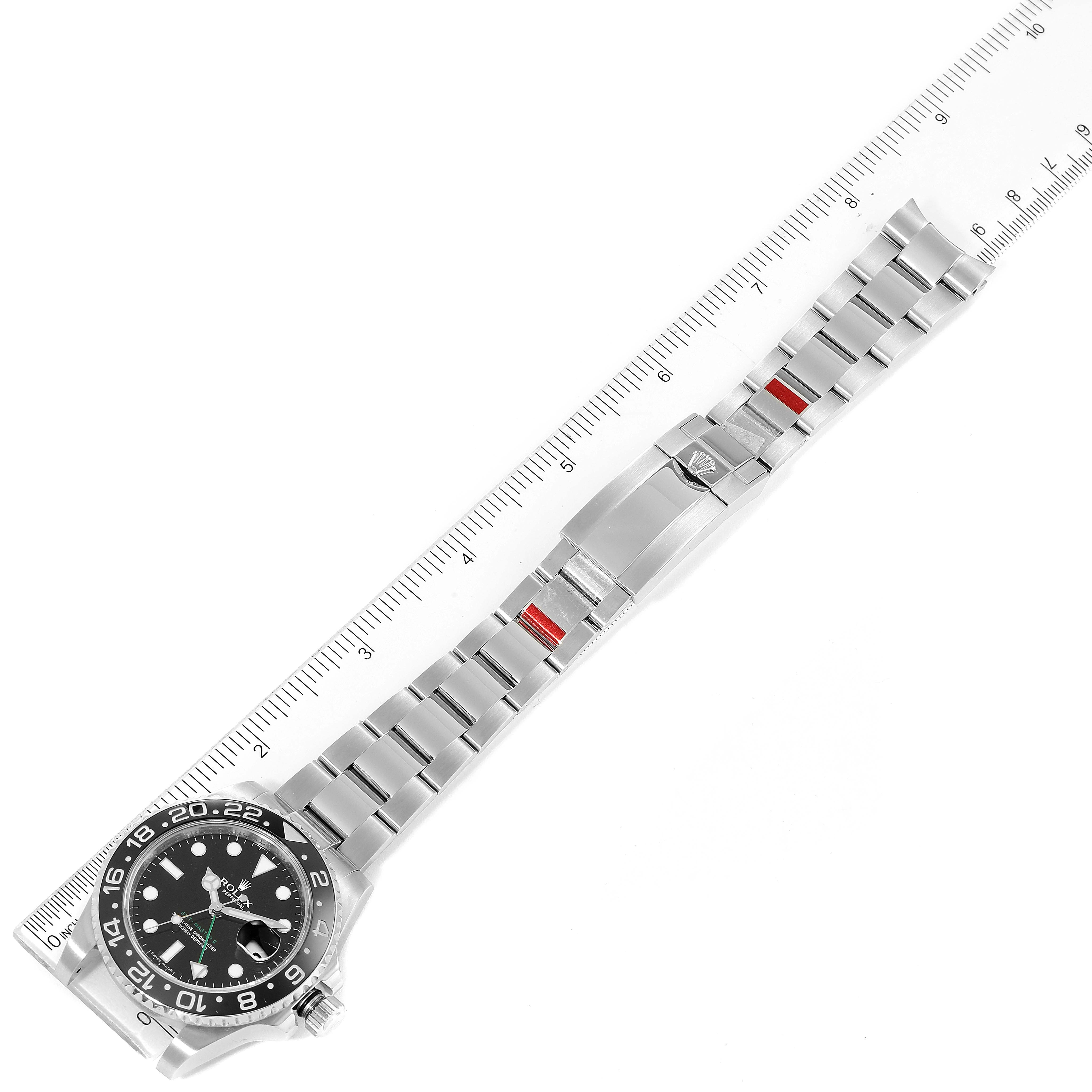 This image shows the Rolex GMT-Master 116710 Men
s Stainless Steel Black Dial 116710 Men
s Stainless Steel Black Dial watch with its dial face and full metal bracelet, laid flat next to a ruler.