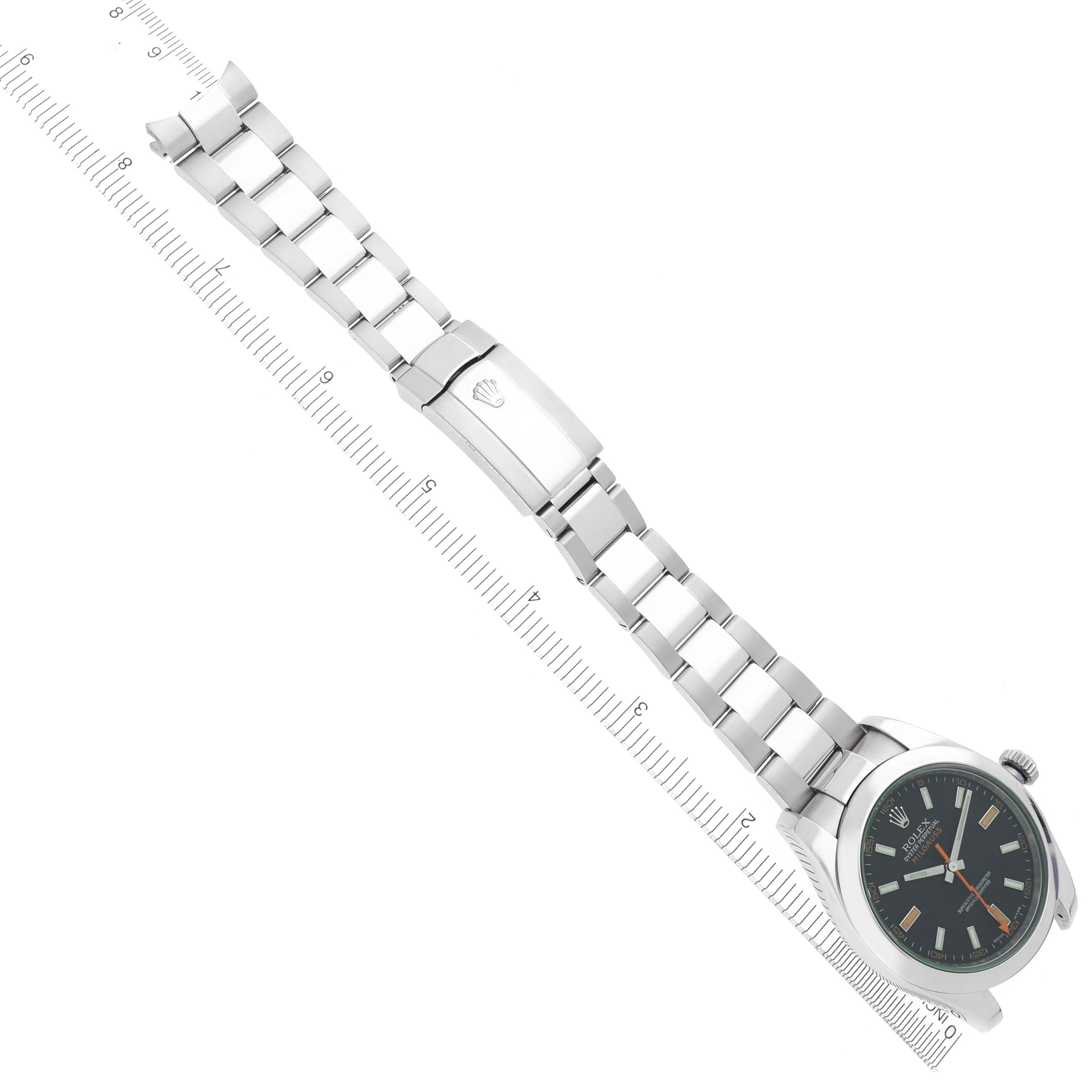 The image shows a Rolex Milgauss 116400 Men
s Stainless Steel Black Dial watch lying flat, displaying the watch face, bracelet, and clasp against a ruler for scale.