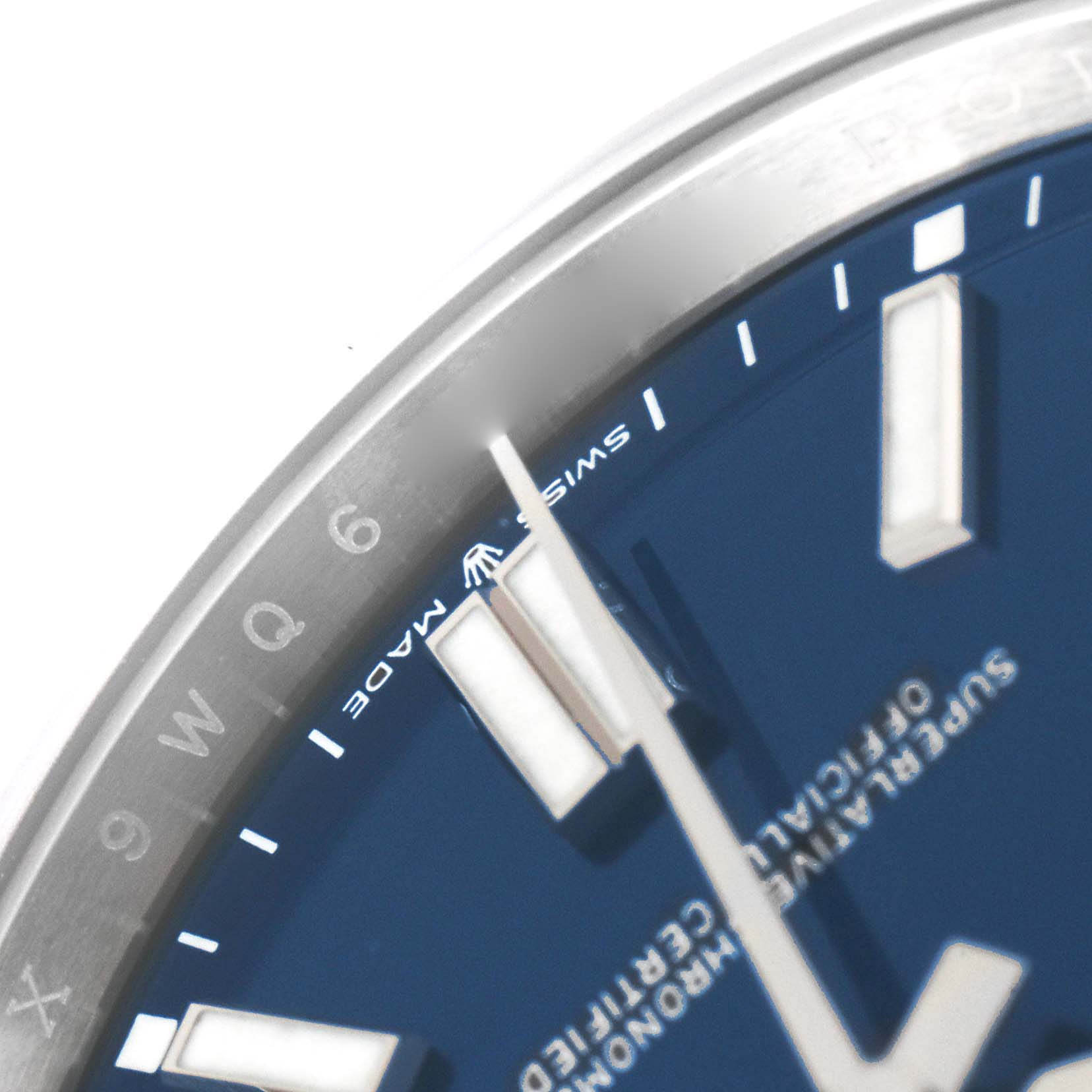 The image shows a close-up view of the dial and part of the rim of a Rolex Oyster Perpetual 124300 Men
s Stainless Steel Blue Dial 124300 Men
s Stainless Steel Blue Dial watch.