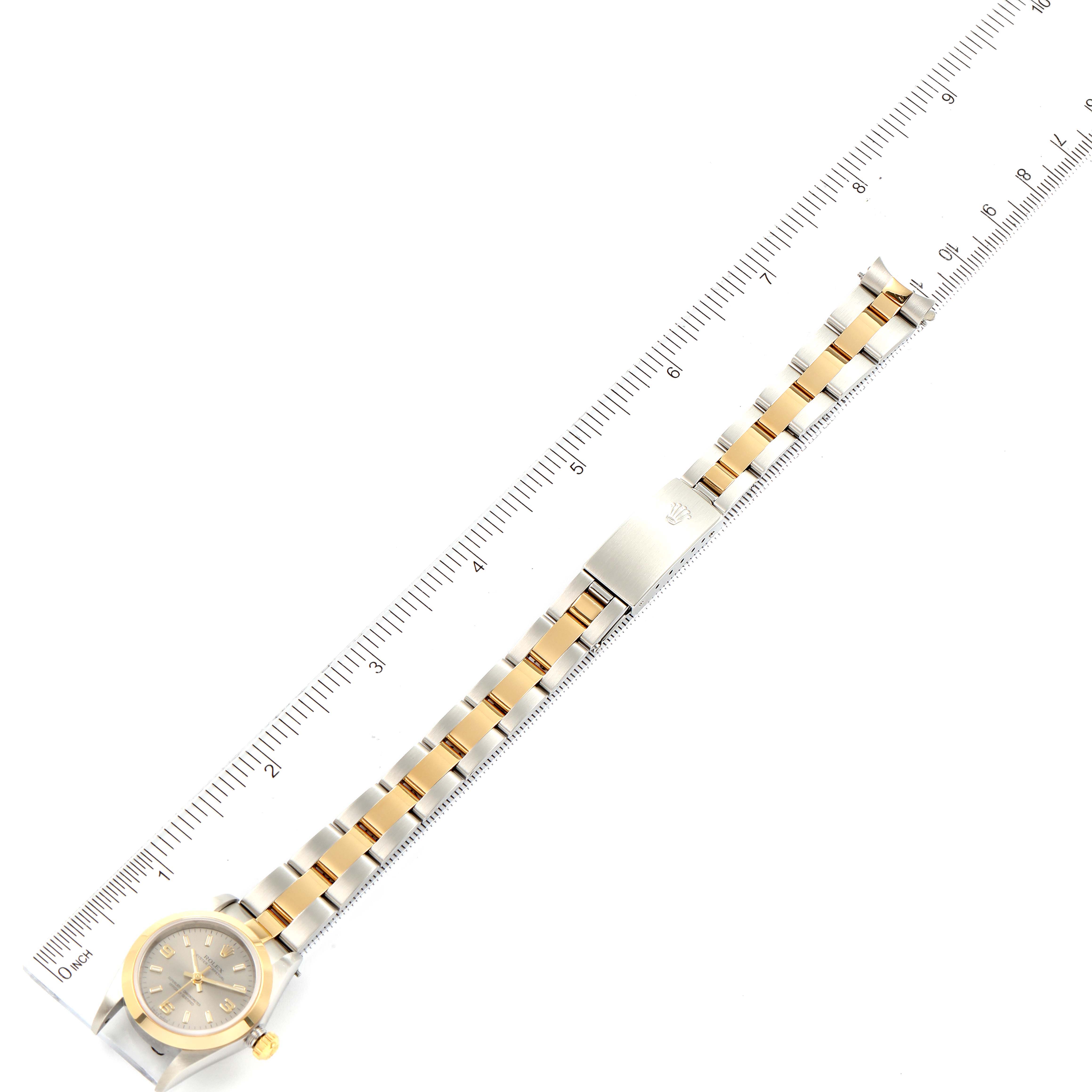 The image shows a Rolex Oyster Perpetual 76183 Women's Steel and Gold (two tone) Grey Dial 76183 Women's Steel and Gold (two tone) Grey Dial watch laid flat with a ruler for scale, displaying the face and two-tone metal band.