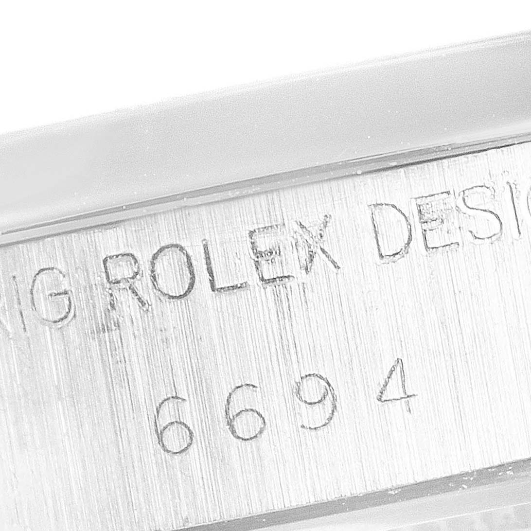 The image shows a close-up of the side engraving on the case of a Rolex Vintage Collection 6694 Men's Stainless Steel Silver Dial 6694 Men's Stainless Steel Silver Dial model, displaying "ROLEX DESIGN 6694".