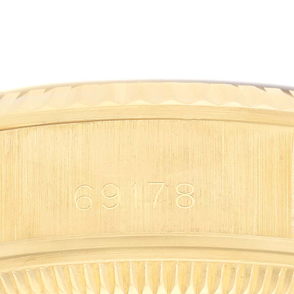 The image shows a close-up of the side of a Rolex President 69178 Women
s Yellow Gold Champagne Dial watch, focusing on the model number engraving on the case.