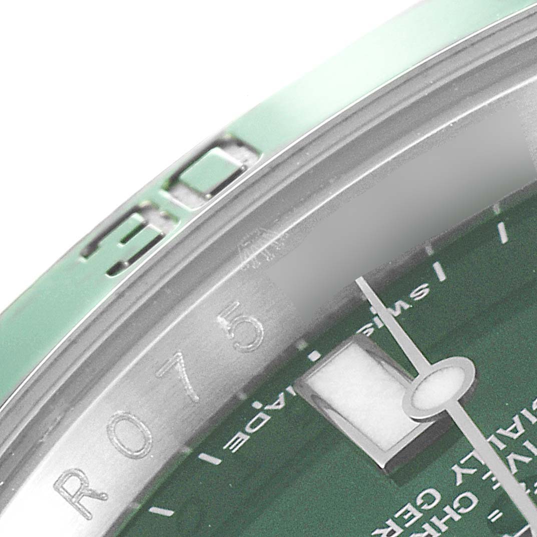 The image shows a close-up of a Rolex Submariner 116610LV Men's Stainless Steel Green Dial 116610LV Men's Stainless Steel Green Dial watch's bezel and part of the dial at an angled view.