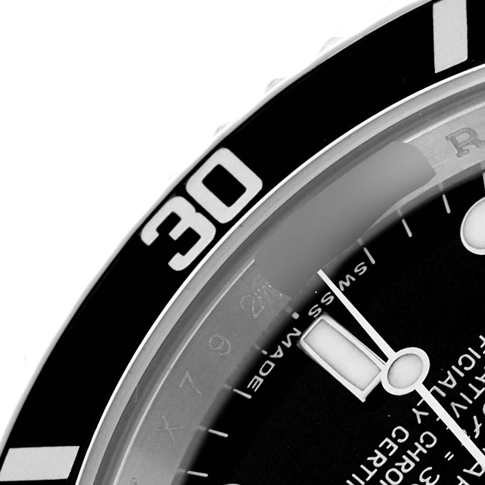 The image shows a close-up of the Rolex Submariner 14060 Men
s Stainless Steel Black Dial
s bezel, part of the dial, and hour markers from a tilted angle.