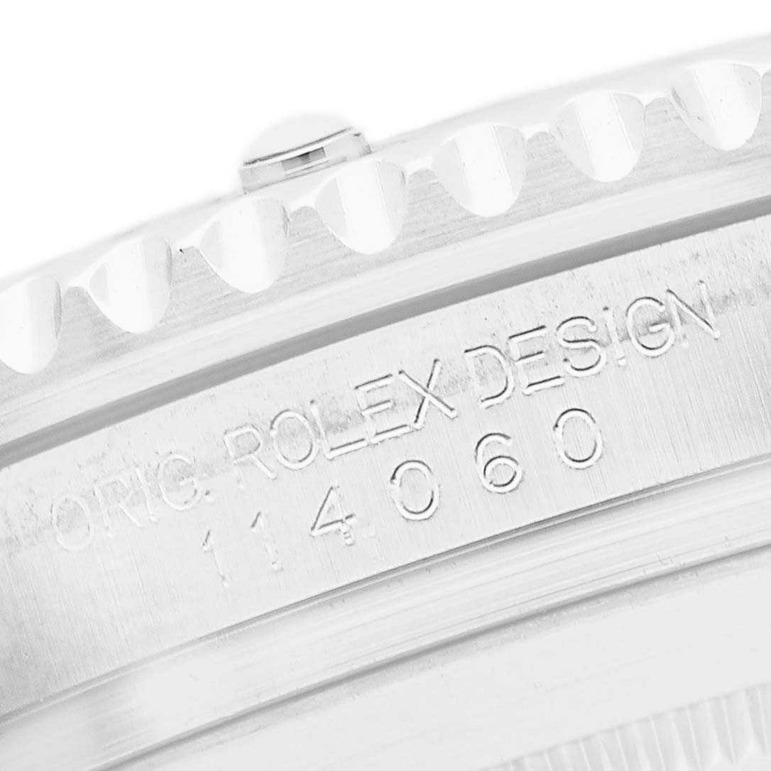 The image shows the edge of the bezel and engraved case side of a Rolex Submariner 114060 Men's Stainless Steel Black Dial, highlighting its model number.