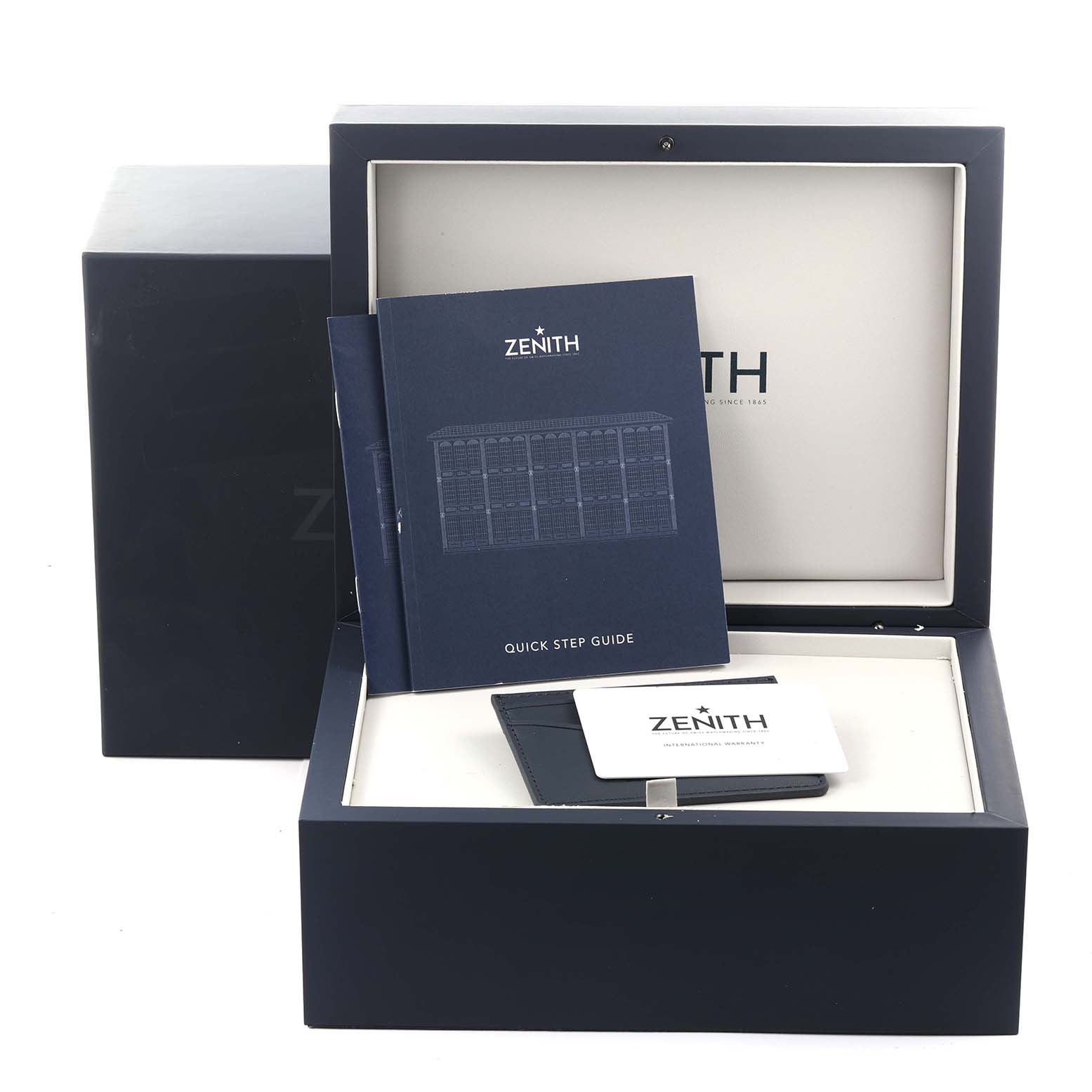 The Zenith El Primero 03.3100.3600 Men
s Stainless Steel White Dial watch accessories are shown with a box, manual, and warranty card from a frontal angle.