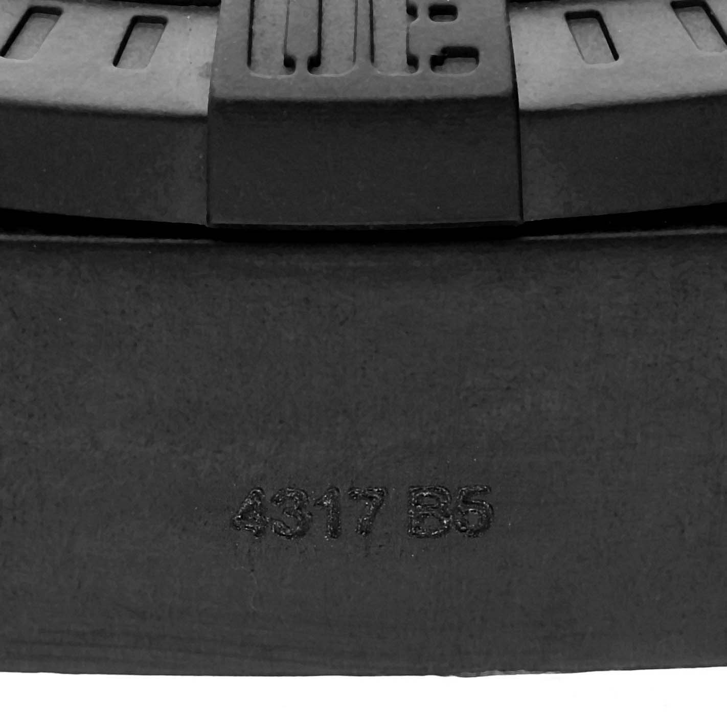 This image shows a close-up view of the back casing and part of the bezel of the Breitling Avenger XB1210E41B1S1 Men's Titanium Black Dial XB1210E41B1S1 Men's Titanium Black Dial watch, including a serial number inscription.