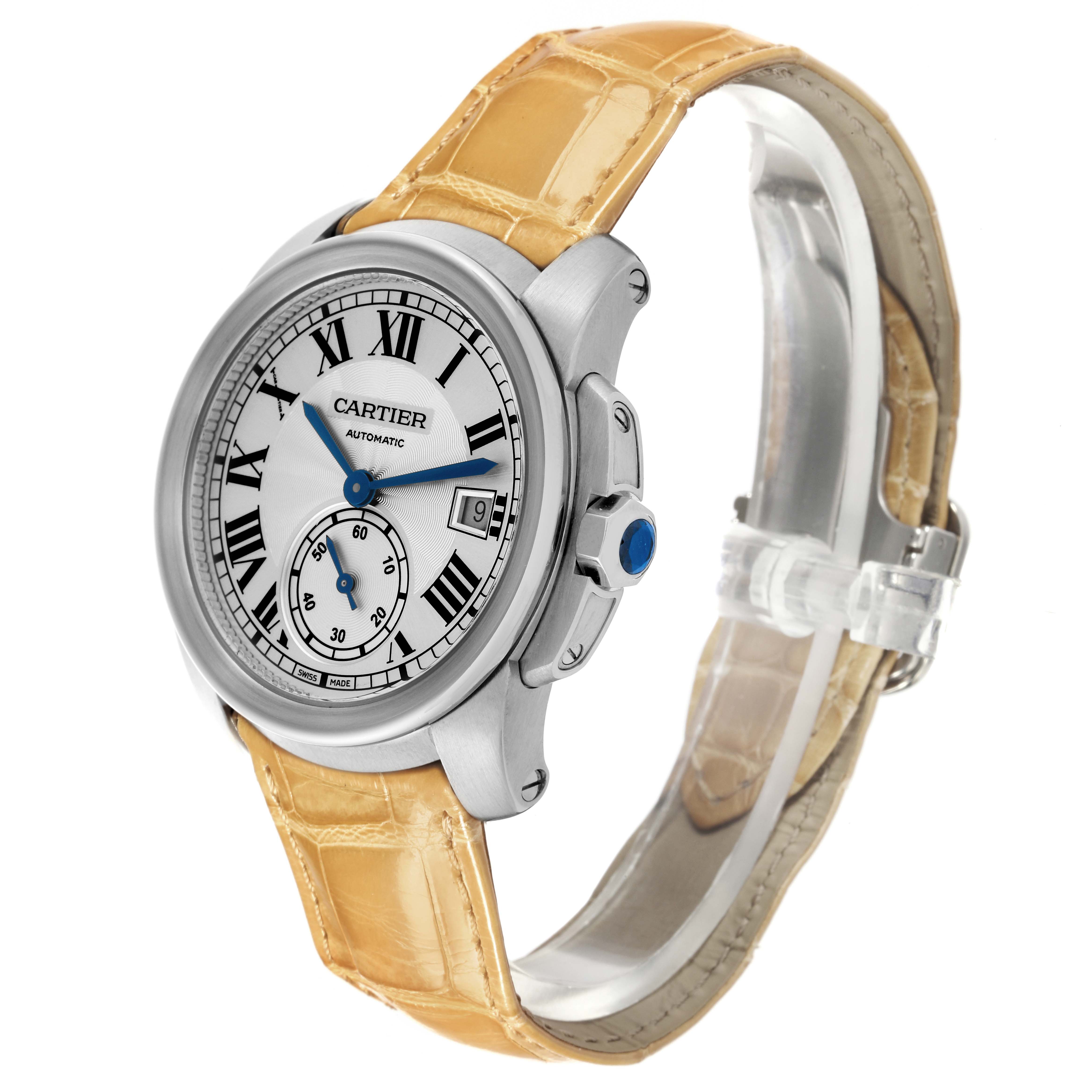 The image shows a front-left angle of the Calibre de Cartier watch, displaying the face, bezel, crown, and beige leather strap.