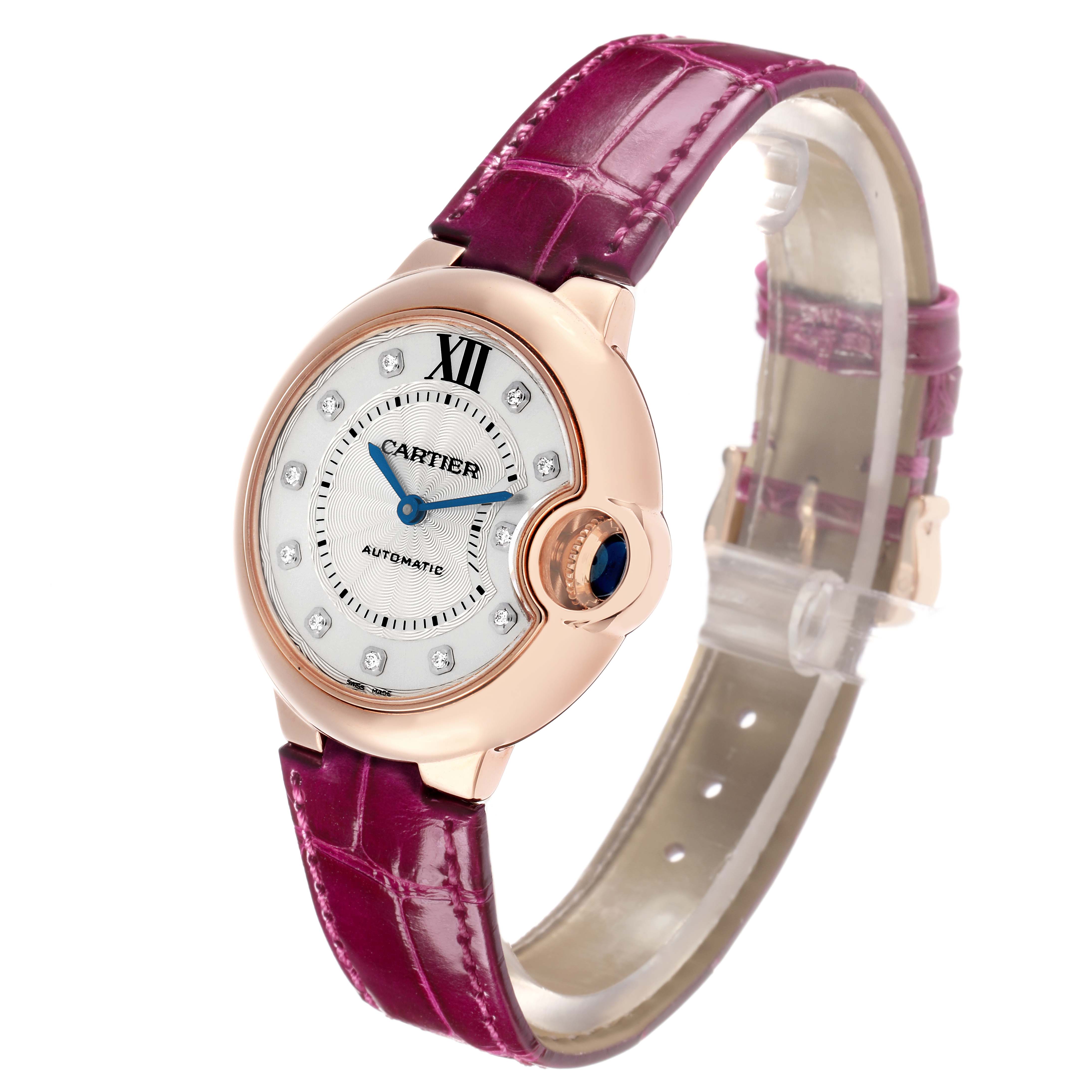 The Cartier Ballon Bleu WE902063 Women
s Rose Gold Silver Dial watch is shown at a slight angle, highlighting its face, rose gold case, and purple leather strap.