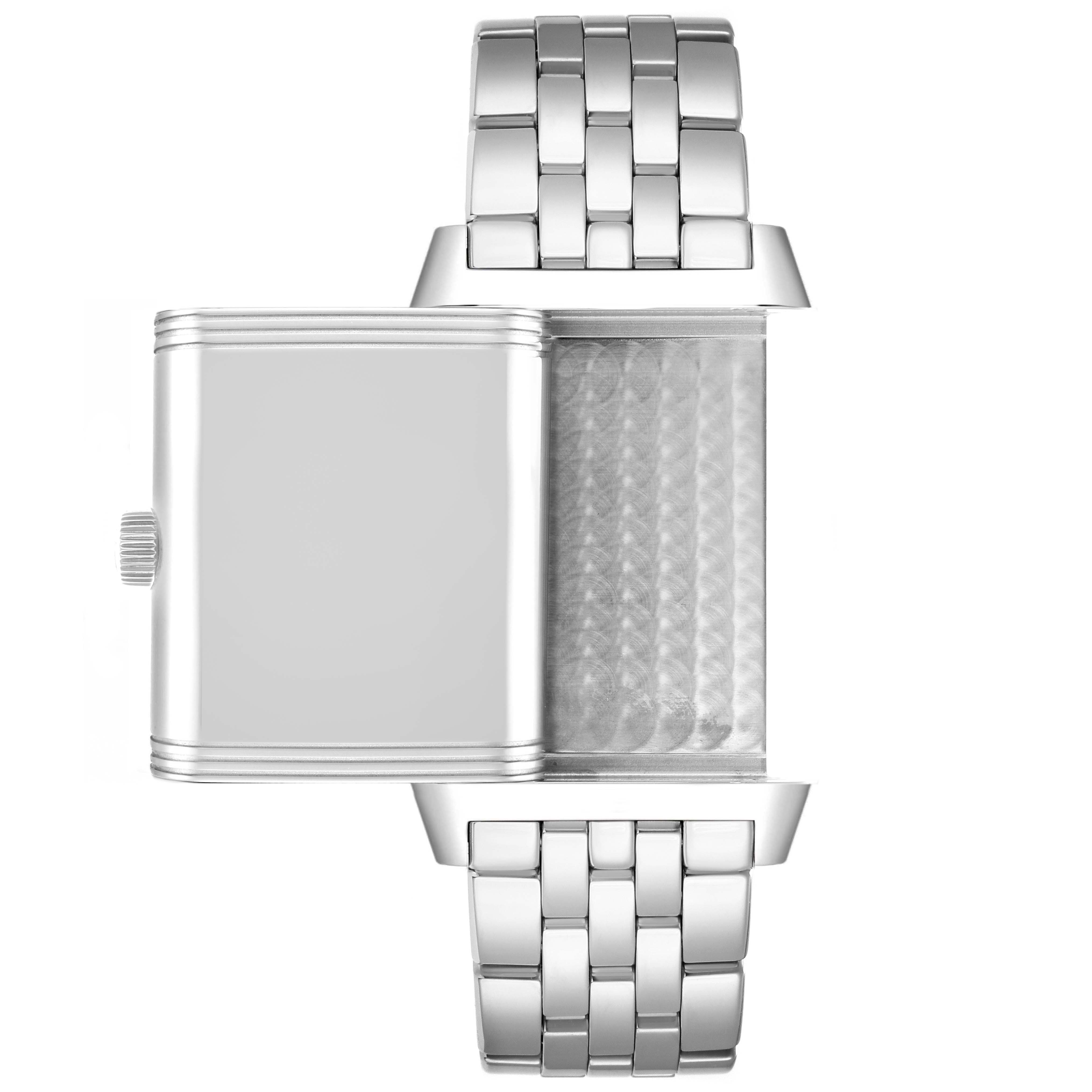 The image shows a Jaeger-LeCoultre Reverso watch from the top angle with its case flipped, displaying the inner mechanism and metal bracelet.