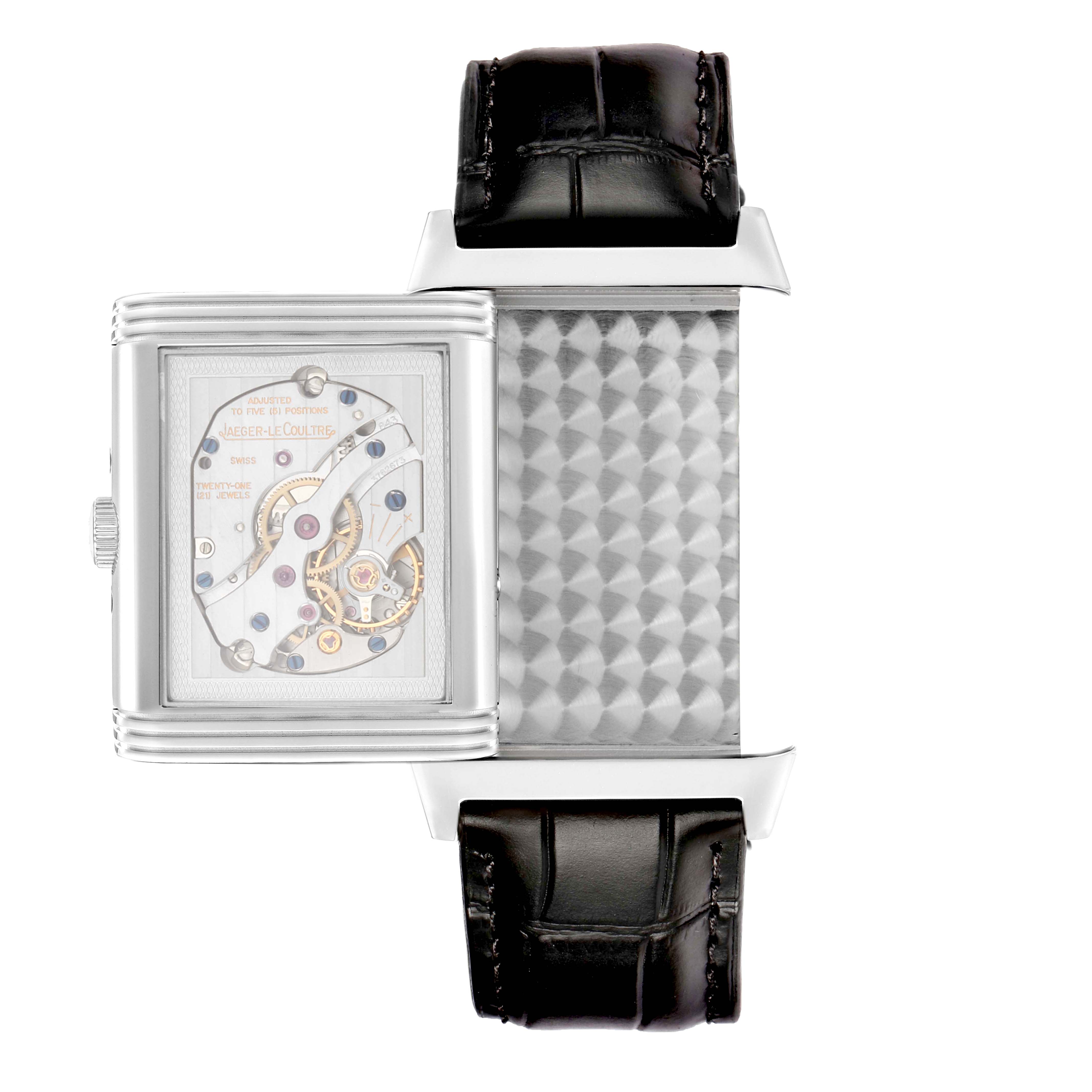 The Jaeger-LeCoultre Reverso watch is shown from the side, revealing its inner mechanism and strap attachment.