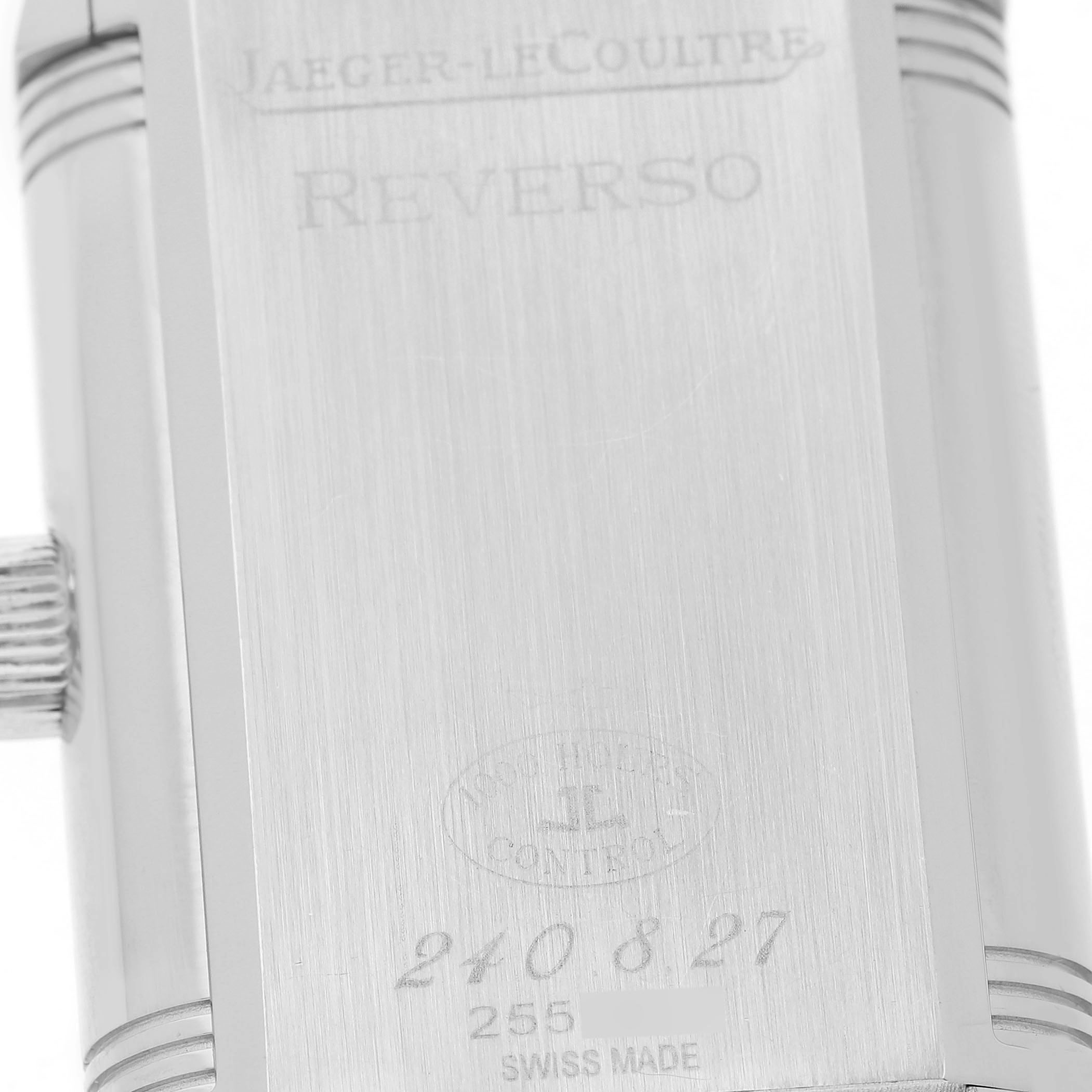 The image shows the back case of a Jaeger-LeCoultre Reverso watch at a close-up angle, highlighting engravings and the crown.