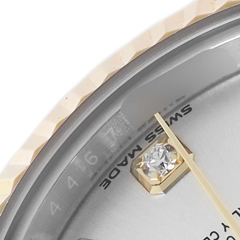 The image shows a close-up of the Rolex Datejust 279173 Women's Steel and Gold (two tone) Silver Dial 279173 Women's Steel and Gold (two tone) Silver Dial watch's bezel, dial, and part of the hand with a diamond hour marker.