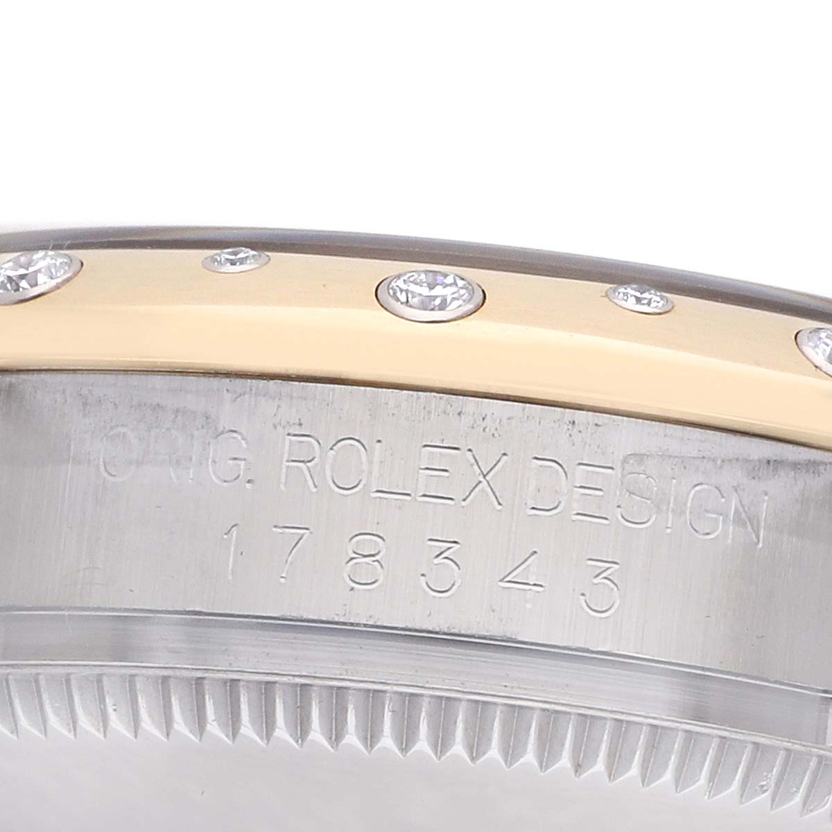 The image shows the side of a Rolex Mid-Size 178343 Women
s Steel and Gold (two tone) Silver Dial watch, focusing on its engraved case and diamond-set bezel.