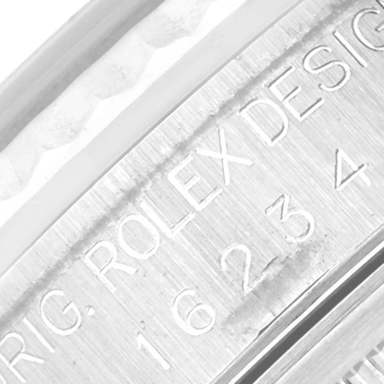 This image shows a close-up of the engraved side of a Rolex Datejust 16234 Men's Stainless Steel Silver Dial 16234 Men's Stainless Steel Silver Dial, highlighting the model number and "Rolex Design" text.