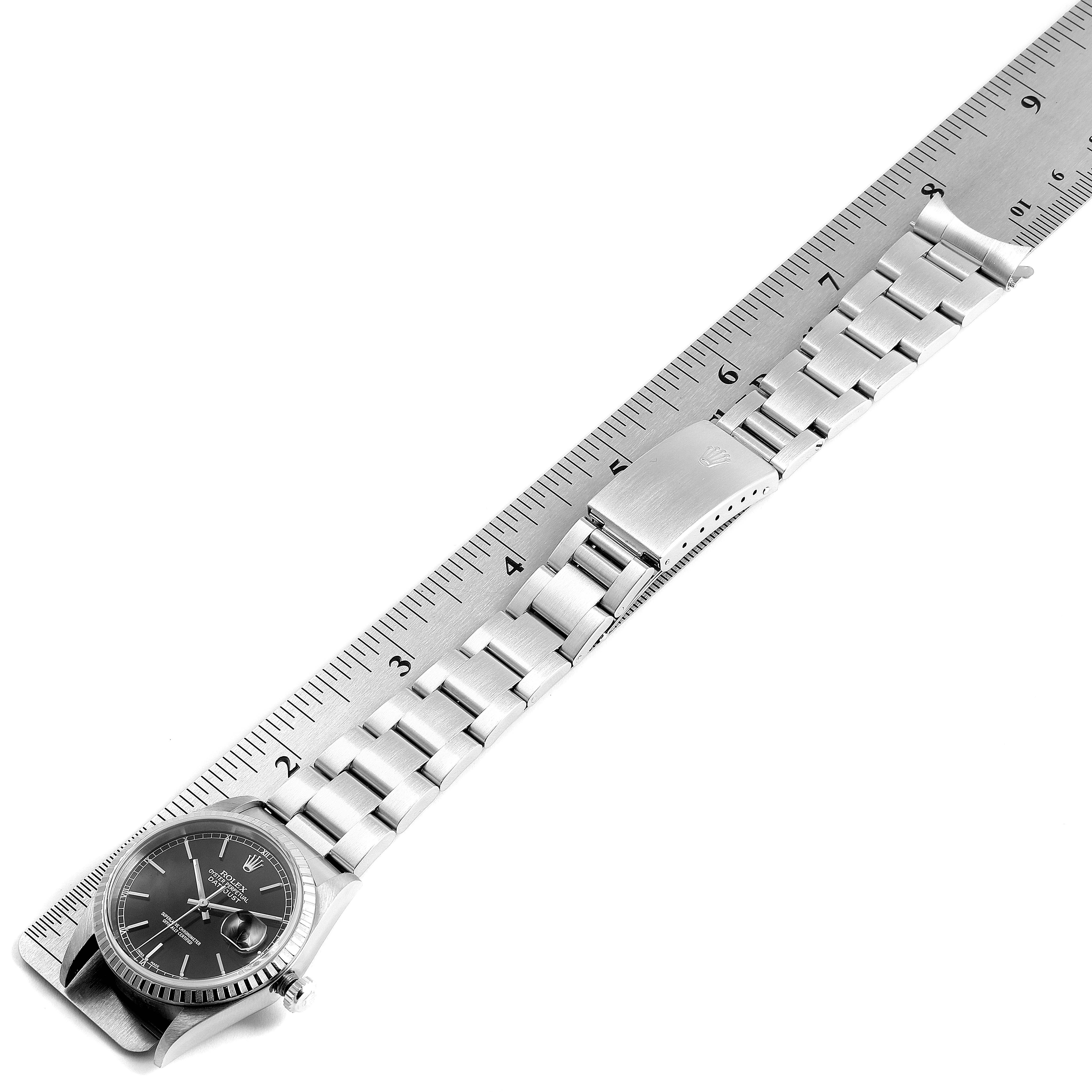 The image shows a Rolex Datejust 16220 Men's Stainless Steel Black Dial 16220 Men's Stainless Steel Black Dial watch laid flat with its bracelet extended next to a ruler for measurement.