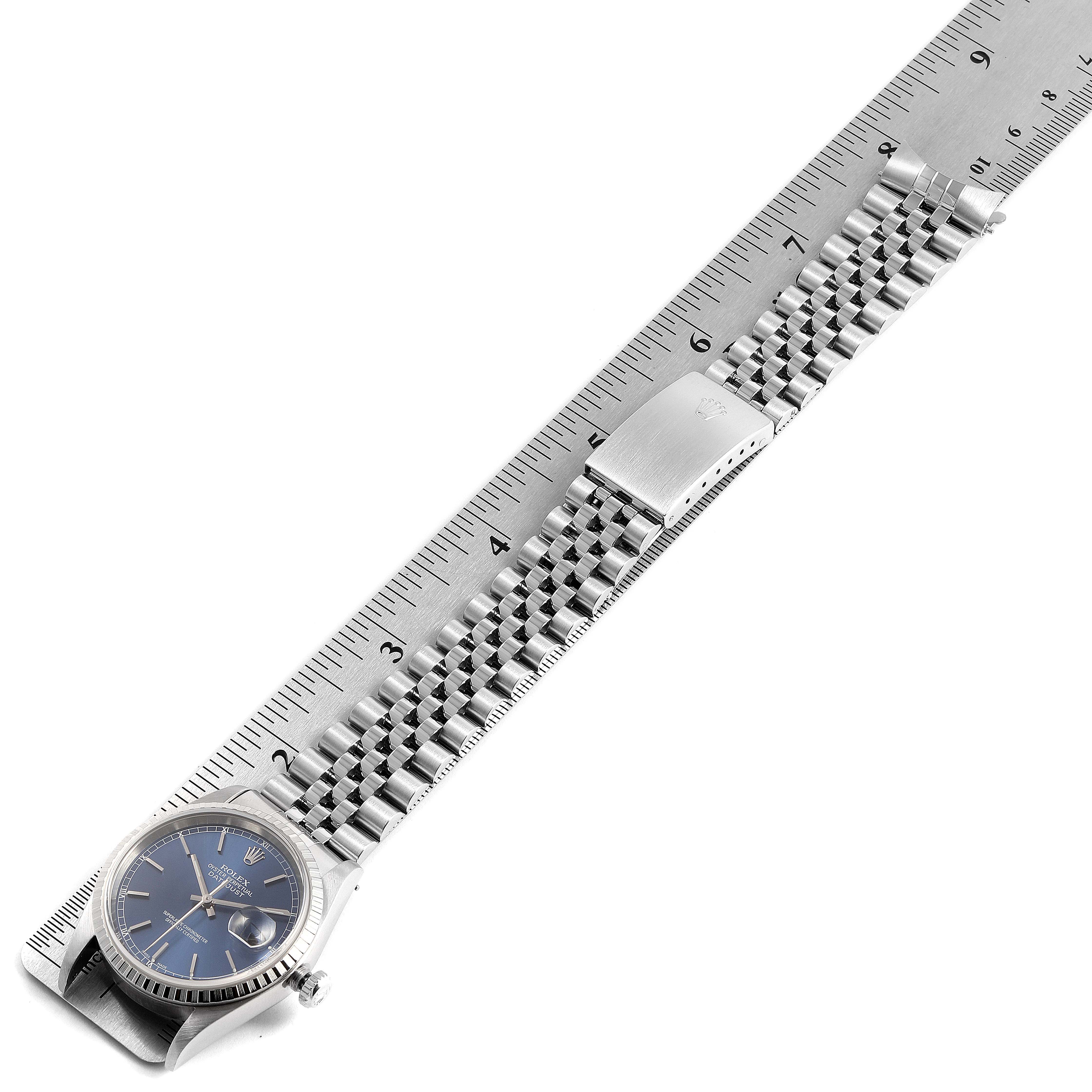 The image shows a Rolex Datejust 16220 Men's Stainless Steel Blue Dial 16220 Men's Stainless Steel Blue Dial watch with its bracelet aligned alongside a ruler for measurement.