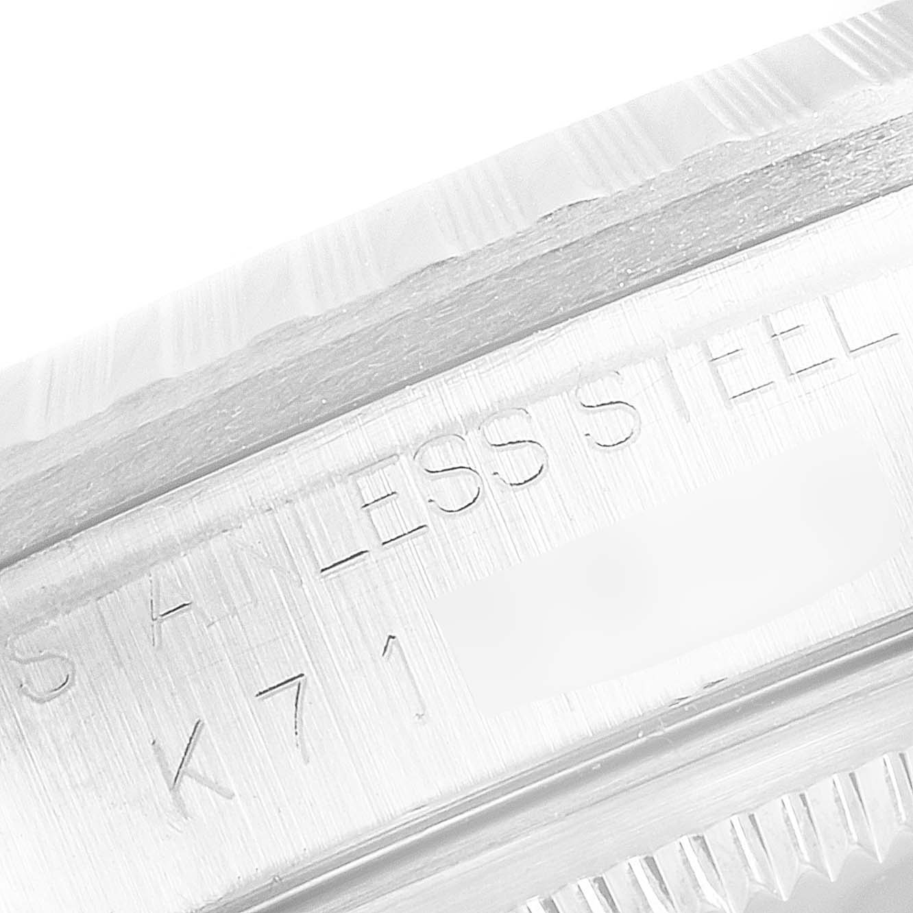 This close-up image of the Rolex Datejust 16220 Men's Stainless Steel Blue Dial 16220 Men's Stainless Steel Blue Dial watch shows the stainless steel engraving and part of the fluted bezel.