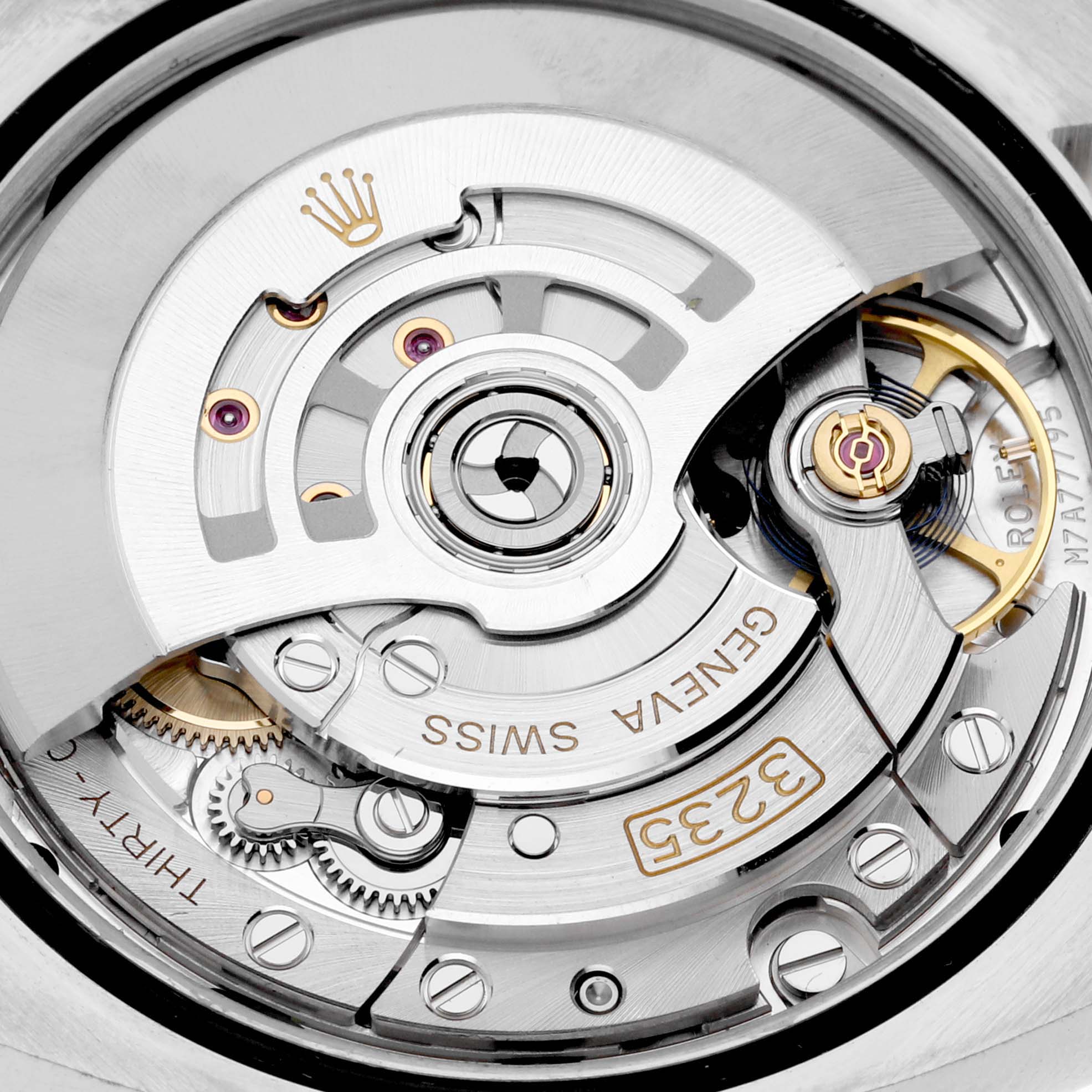 The image shows the intricate movement and rotor mechanism of a Rolex Datejust 126233 Men
s Steel and Gold (two tone) Silver Dial watch from a close-up angle.