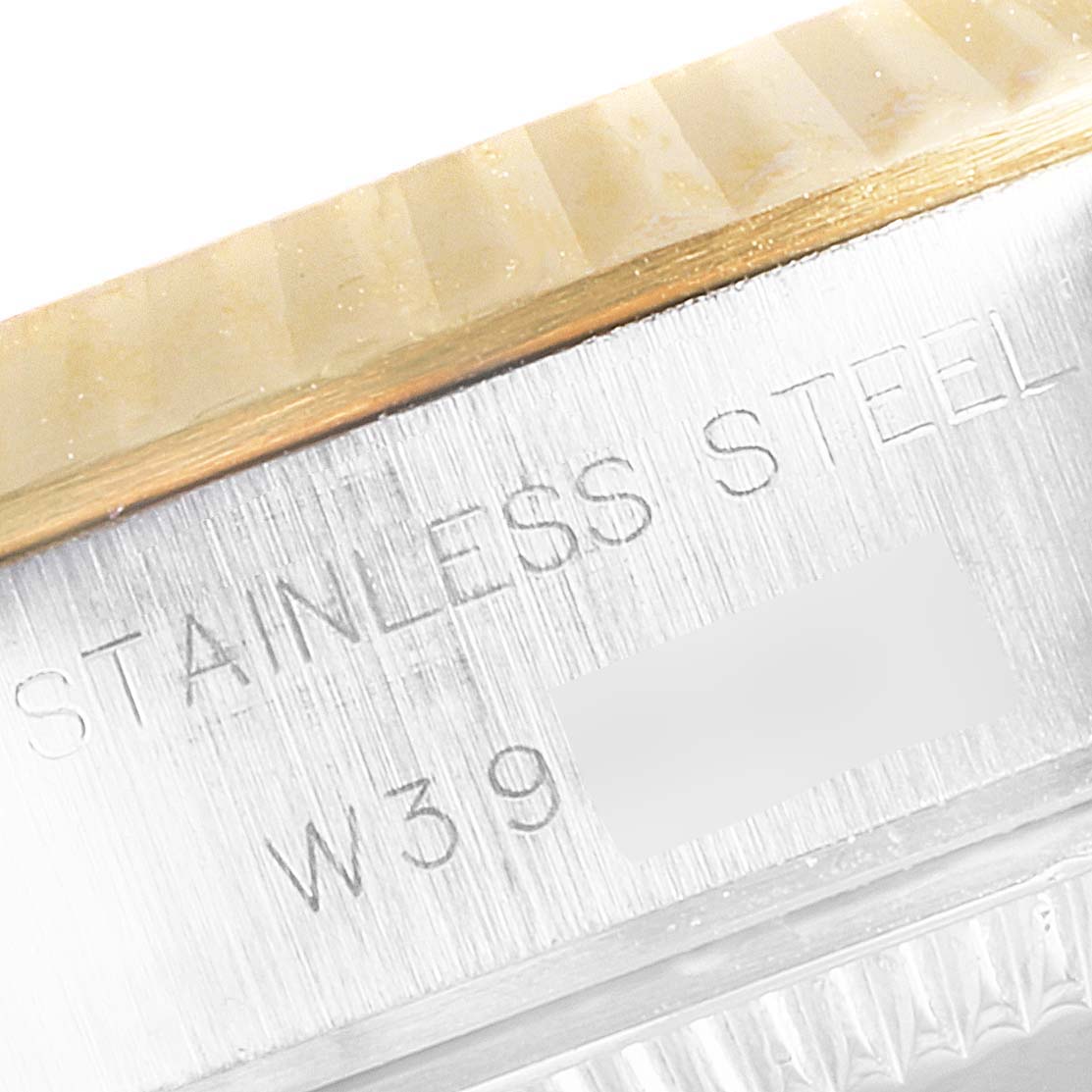 This close-up image shows the side of the bezel and the engraved "STAINLESS STEEL" text on the case of a Rolex Datejust 69173 Women's Steel and Gold (two tone) Black Dial 69173 Women's Steel and Gold (two tone) Black Dial watch.