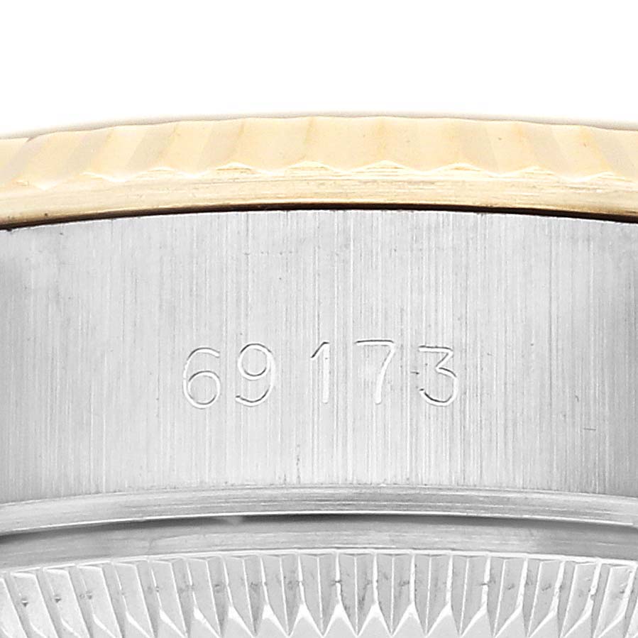 The image shows a close-up of the Rolex Datejust 69173 Women
s Steel and Gold (two tone) Champagne Dial
s fluted bezel and the side case with the model number engraved.