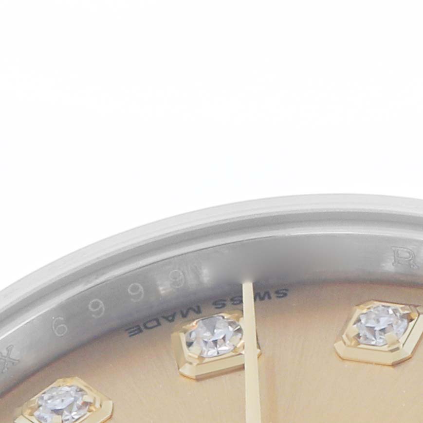The image shows a close-up of the dial and bezel edge of a Rolex Datejust 179173 Women
s Stainless Steel Champagne Dial, highlighting diamond indices and the "Swiss Made" text.