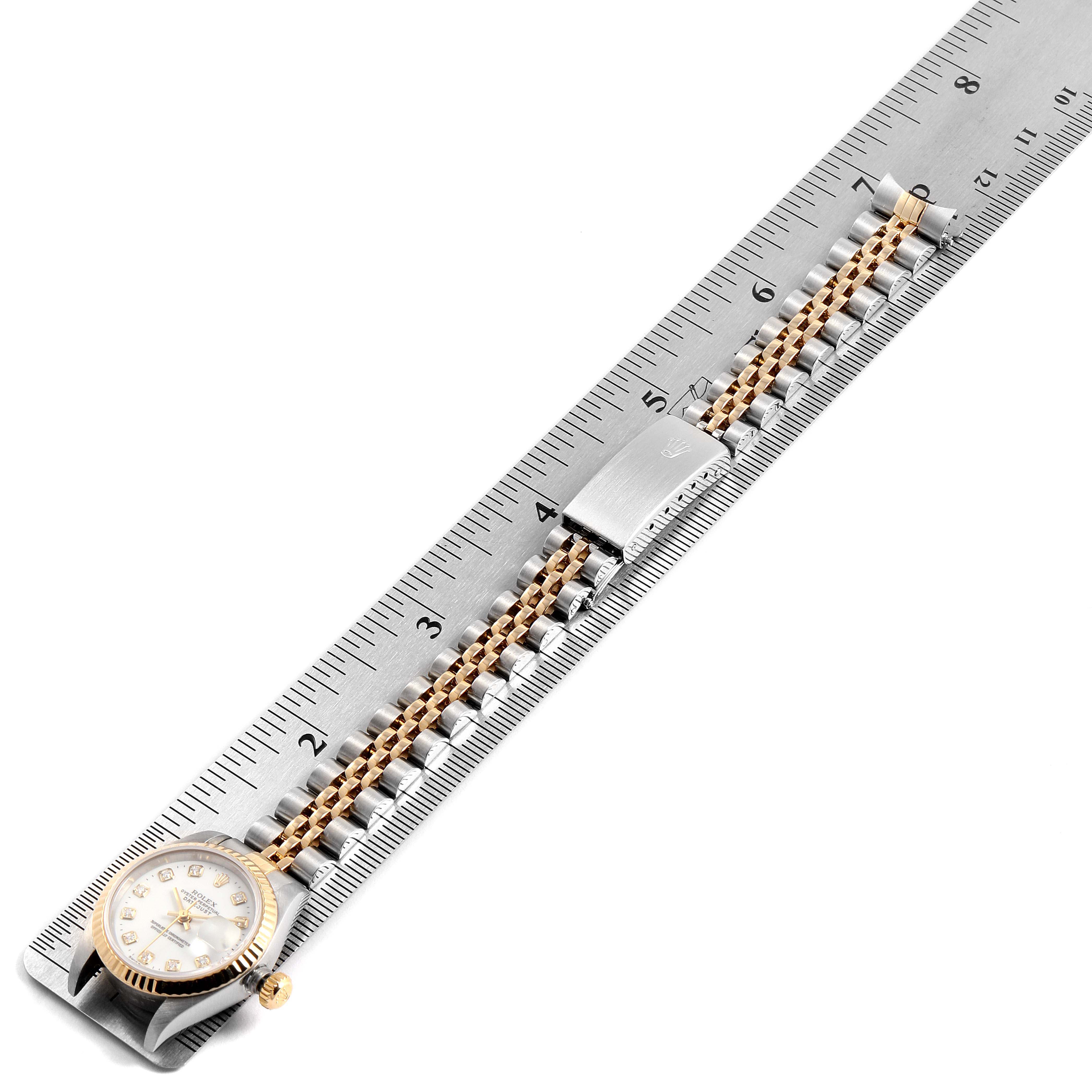 The image shows the Rolex Datejust 69173 Women's Steel and Gold (two tone) White Dial 69173 Women's Steel and Gold (two tone) White Dial watch horizontally aligned on a ruler, highlighting the face and bracelet.