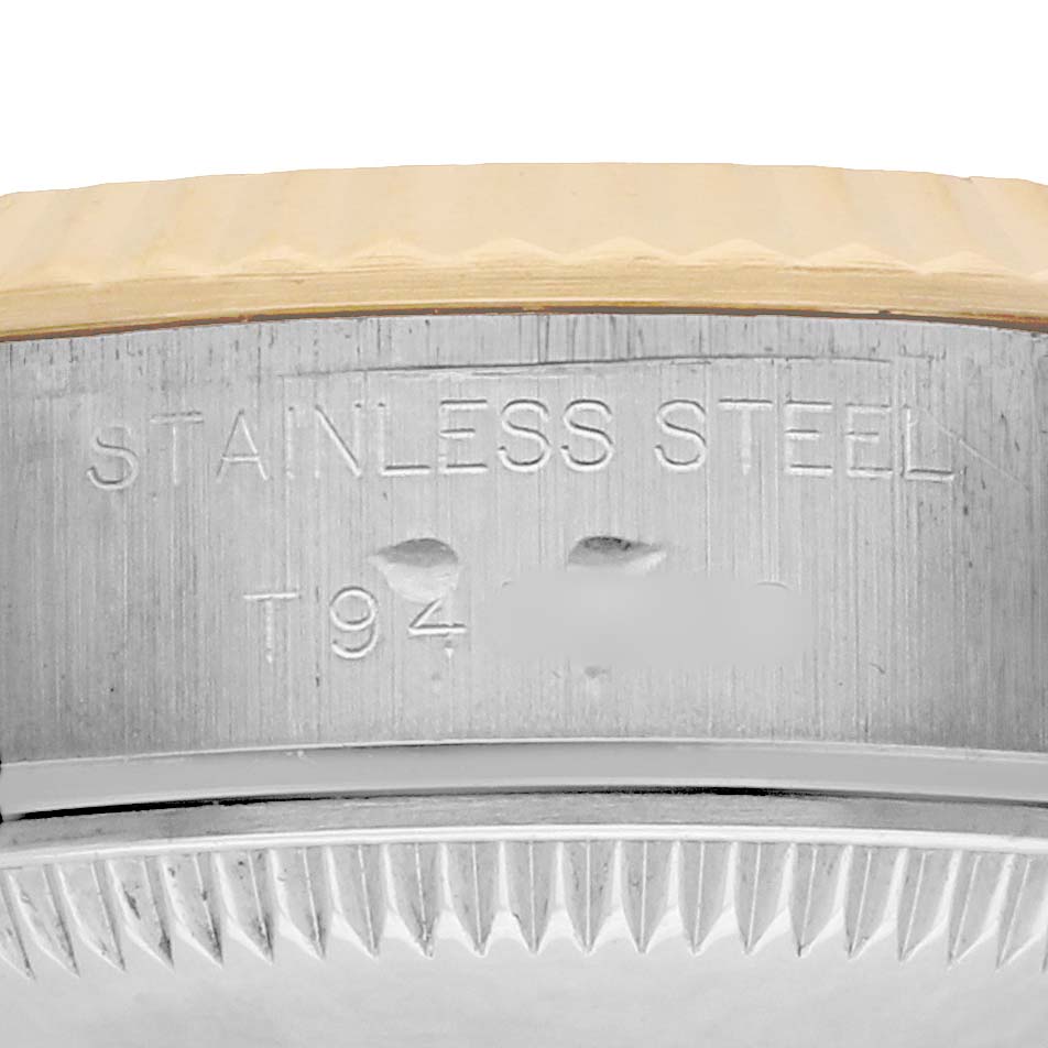 The image shows a close-up of the case side of a Rolex Datejust 69173 Women
s Steel and Gold (two tone) Champagne Dial, highlighting the stainless steel engraving.