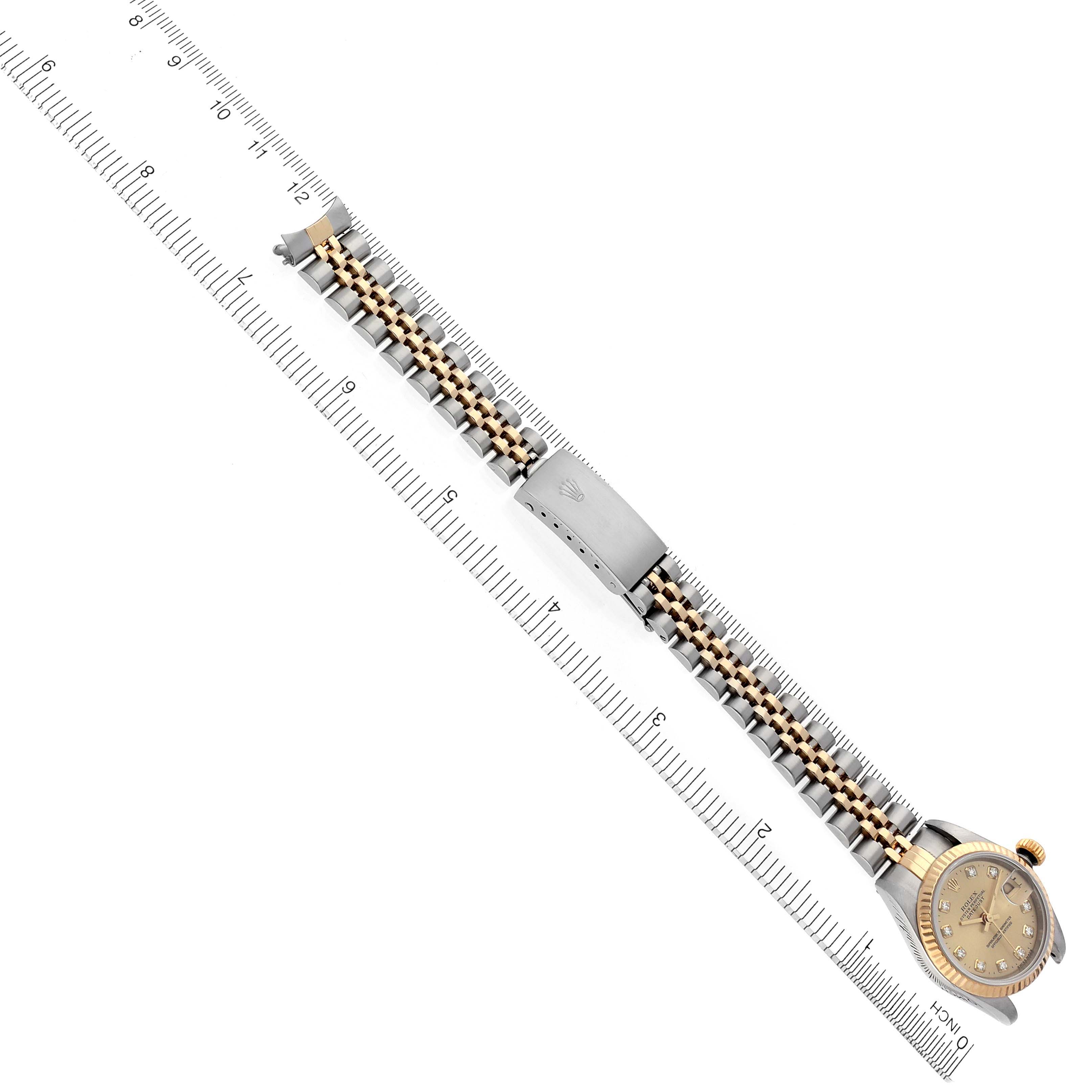 The Rolex Datejust 69173 Women's Steel and Gold (two tone) Champagne Dial 69173 Women's Steel and Gold (two tone) Champagne Dial watch is shown from an angled top-down perspective, displaying the bracelet and clasp alongside a ruler for scale.