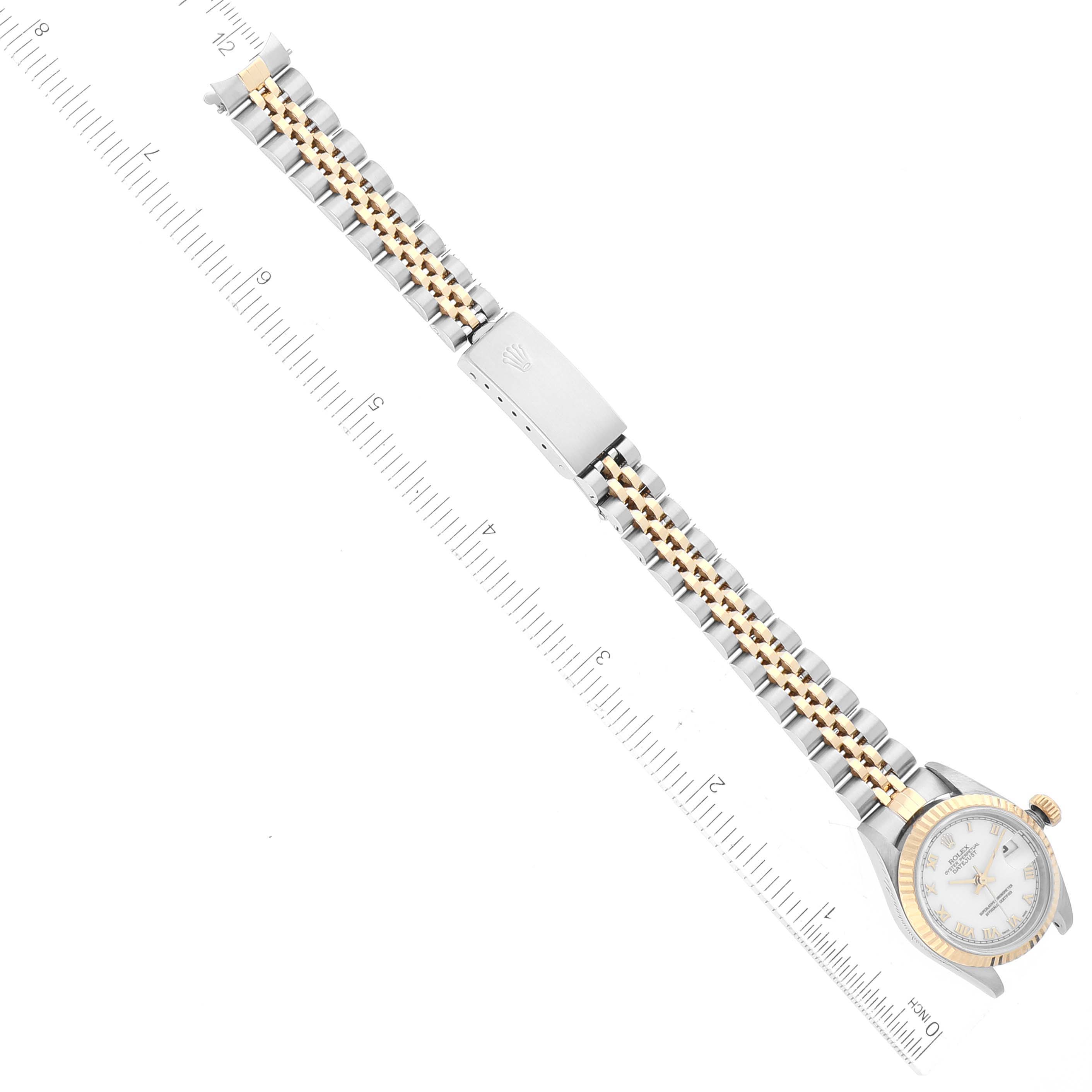 The image shows a top-down view of a Rolex Datejust 79173 Women's Steel and Gold (two tone) White Dial 79173 Women's Steel and Gold (two tone) White Dial watch, displaying the dial, bracelet, and clasp on a ruler for scale.