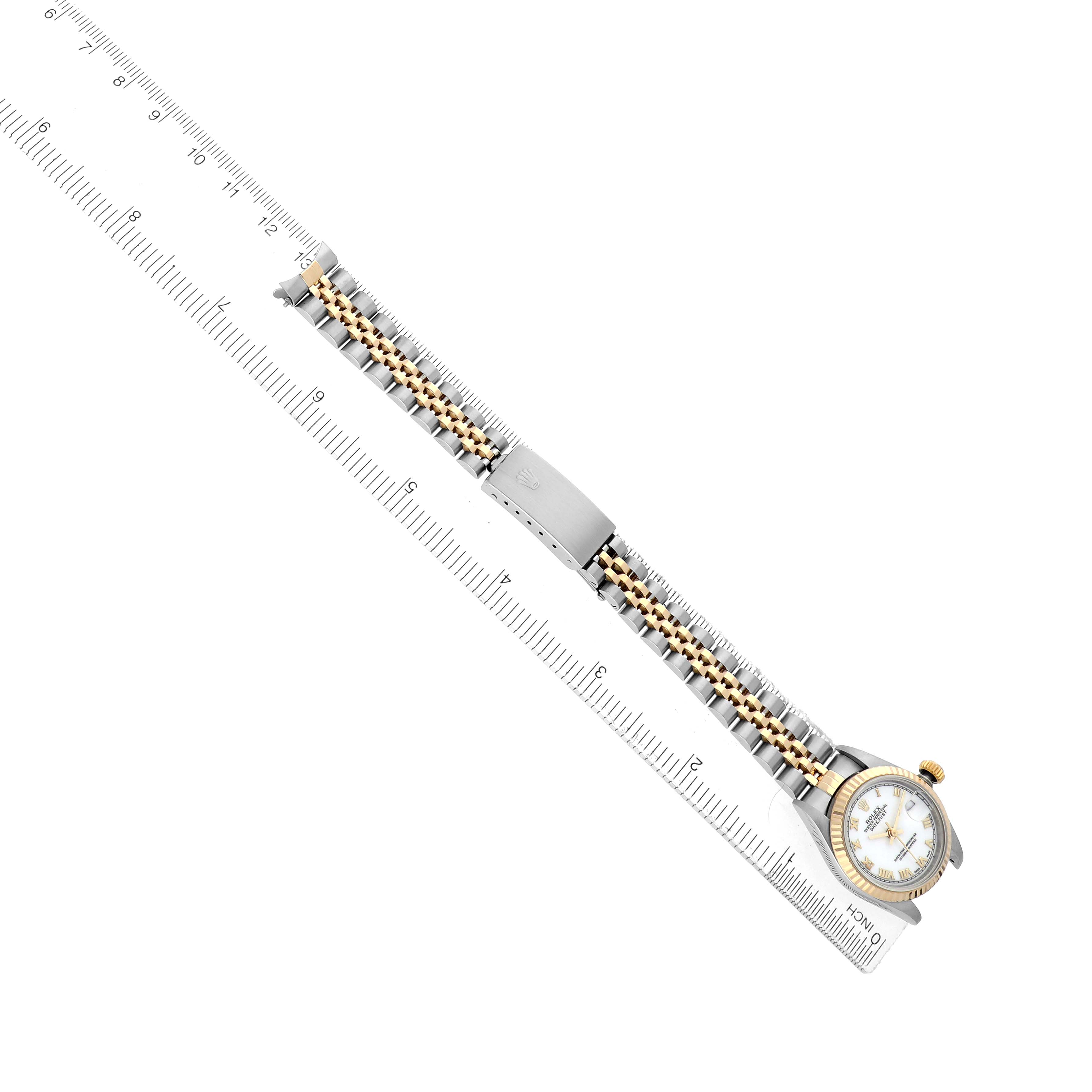 The Rolex Datejust 69173 Women
s Steel and Gold (two tone) White Dial watch is shown diagonally, highlighting the bracelet, clasp, and part of the dial with a ruler in view.