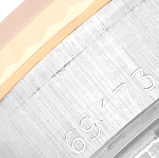 This image shows a close-up of the Rolex Datejust 69173 Women's Steel and Gold (two tone) Champagne Dial 69173 Women's Steel and Gold (two tone) Champagne Dial's watch bezel and serial number engraving.