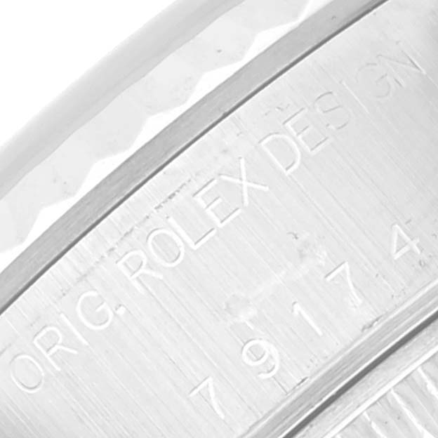 This image shows a close-up of the Rolex Datejust 79174 Women's Stainless Steel Silver Dial 79174 Women's Stainless Steel Silver Dial model's case with engraved branding details.