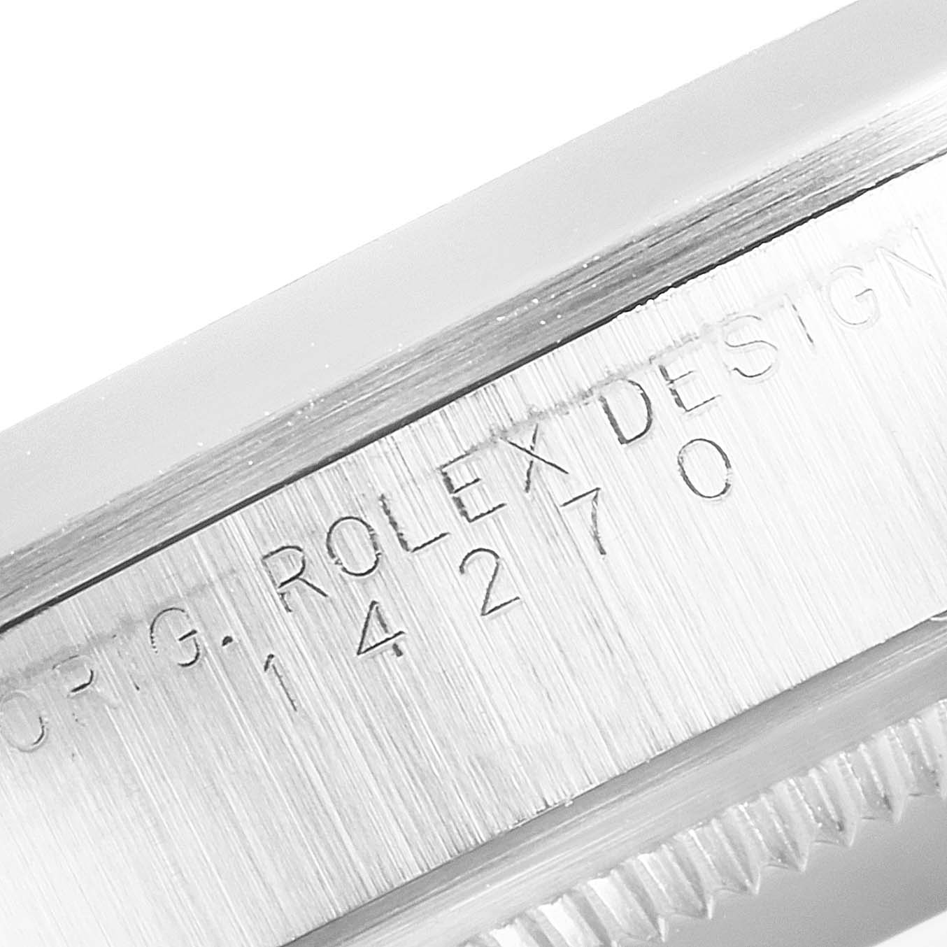 The image shows a close-up of the engraved side of a Rolex Explorer 14270 Men
s Stainless Steel Black Dial 14270 Men
s Stainless Steel Black Dial watch, including part of its case and bezel.