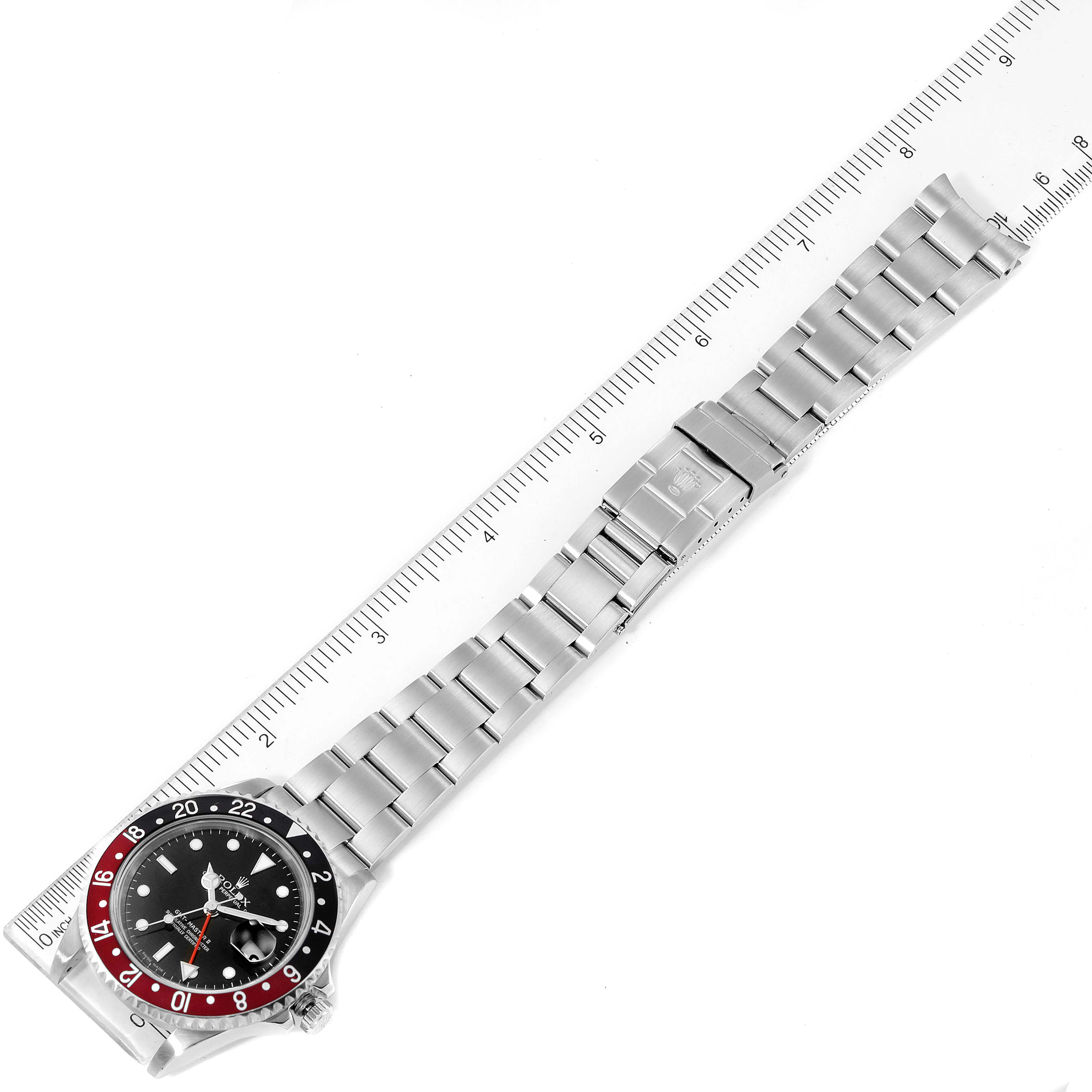 The image shows a top-down view of the Rolex GMT-Master 16710 Men's Stainless Steel Black Dial 16710 Men's Stainless Steel Black Dial watch including the dial, bezel, bracelet, and a ruler for scale.