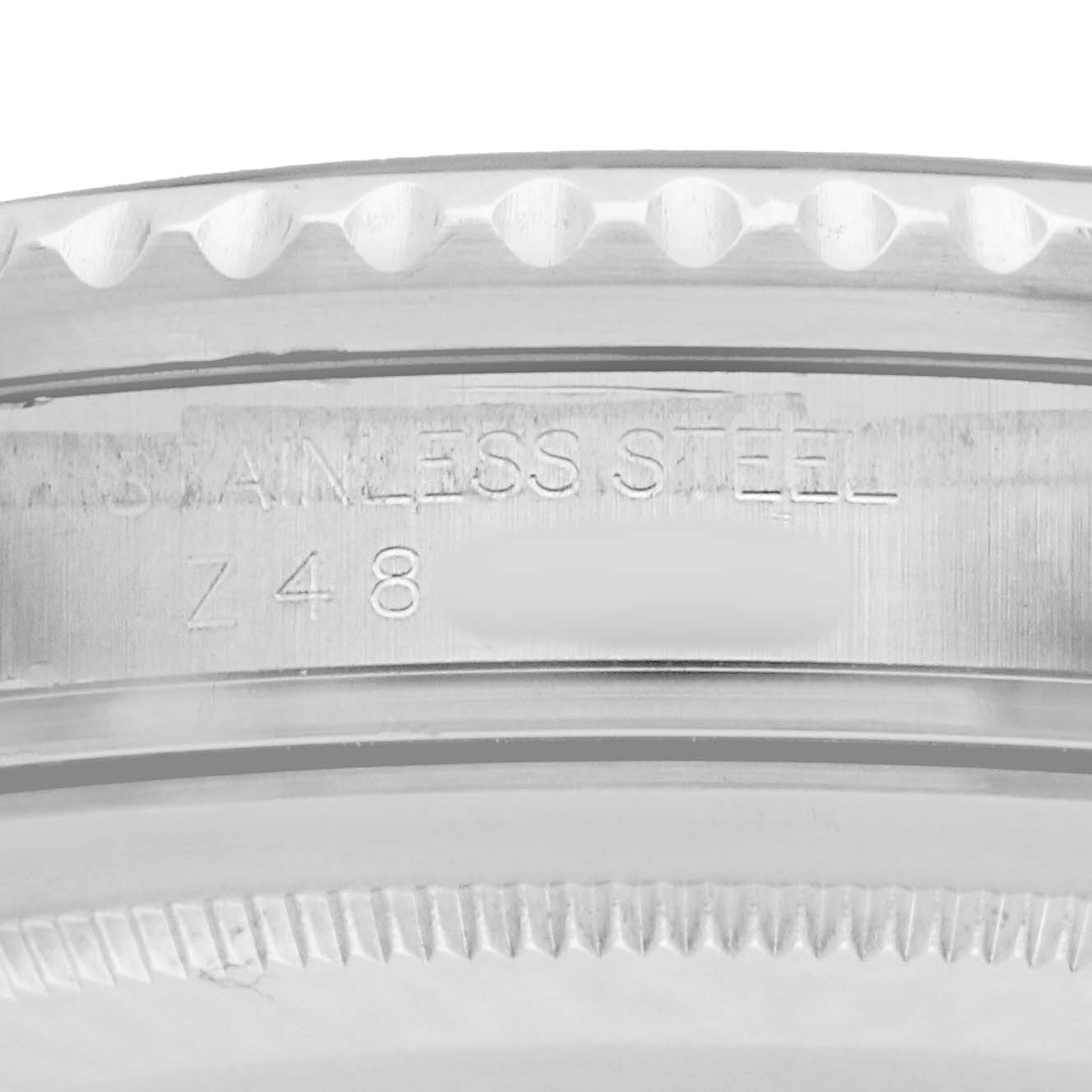 The image shows an angled close-up of the side of a Rolex GMT-Master 16710 Men
s Stainless Steel Black Dial watch, highlighting its stainless steel case and serial engraving.