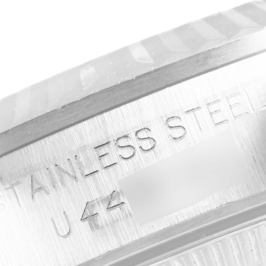 This close-up image shows the side of the case of a Rolex Oyster Perpetual 67194 Women's Stainless Steel Silver Dial 67194 Women's Stainless Steel Silver Dial watch, featuring part of the bezel and "STAINLESS STEEL" engraving.