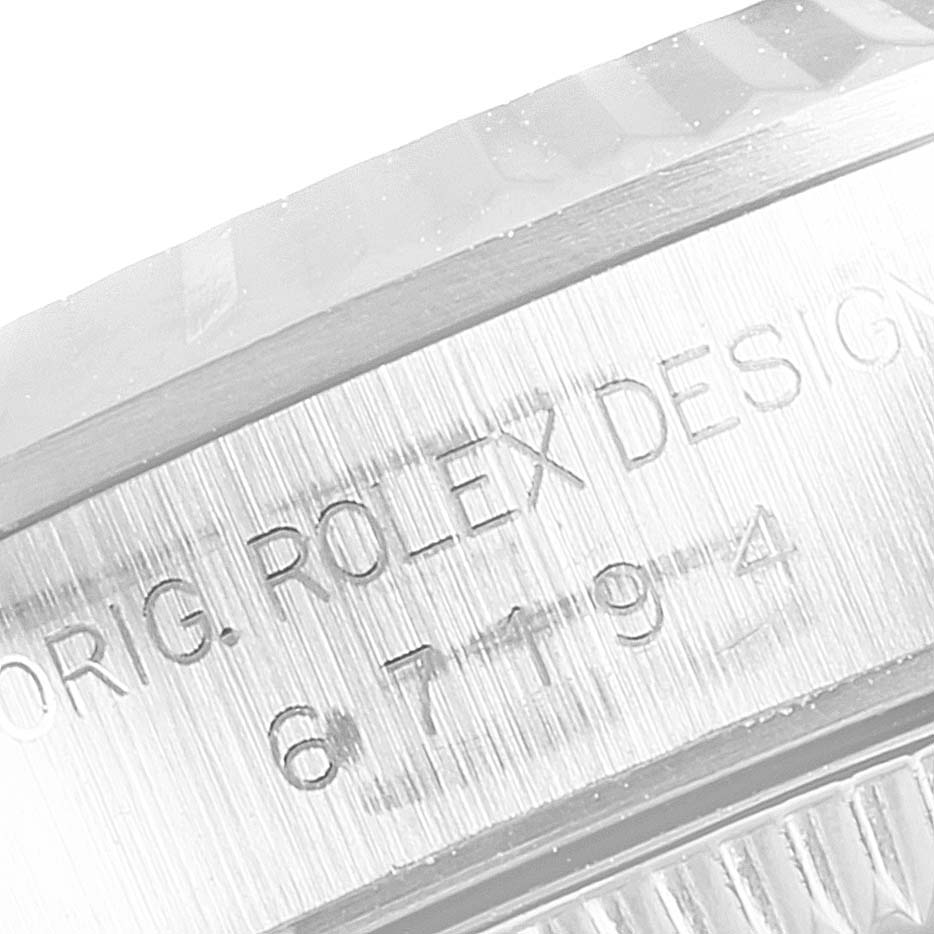 This image shows a close-up of the engraved side of a Rolex Oyster Perpetual 67194 Women's Stainless Steel Silver Dial 67194 Women's Stainless Steel Silver Dial watch, displaying "ORIG. ROLEX DESIGN" and part of a serial number.
