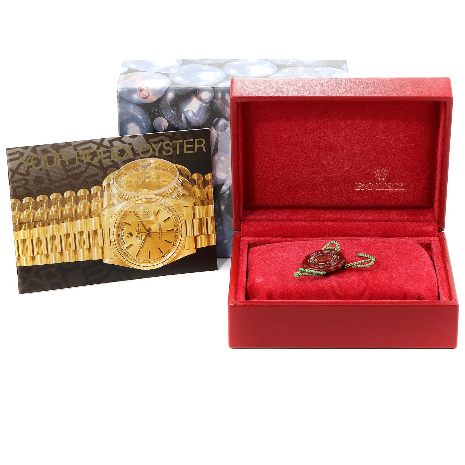 The image shows a red Rolex box for the Oyster Perpetual model, an authentication card, and a tag inside the box.
