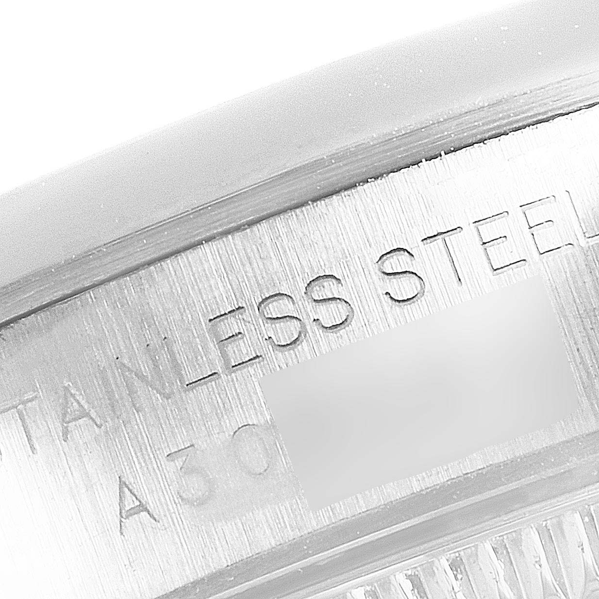 This image shows a close-up view of the case back rim of a Rolex Oyster Perpetual 76080 Women's Stainless Steel Pink Dial 76080 Women's Stainless Steel Pink Dial watch, highlighting the "STAINLESS STEEL" engraving.