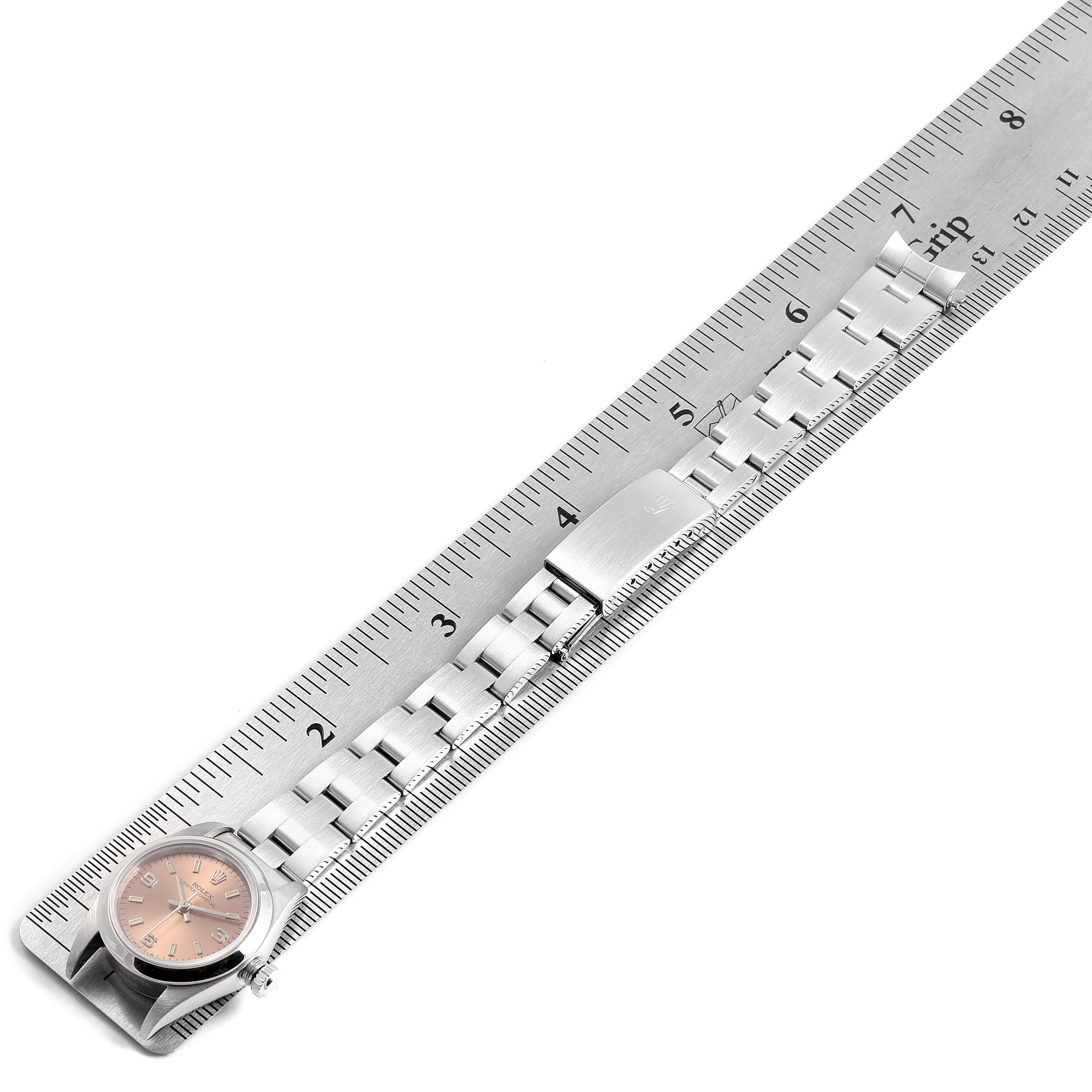 The image shows the full length of a Rolex Oyster Perpetual 76080 Women's Stainless Steel Pink Dial 76080 Women's Stainless Steel Pink Dial watch band laid alongside a ruler, highlighting the watch face and clasp.