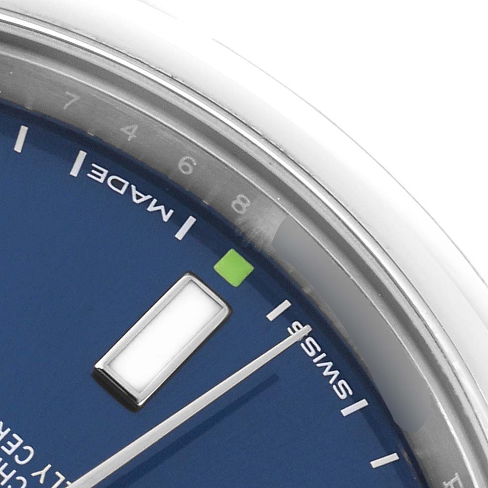 This close-up of a Rolex Oyster Perpetual 114300 Men
s Stainless Steel Blue Dial 114300 Men
s Stainless Steel Blue Dial watch shows the dial with hour markers, minute track, and part of the second hand.