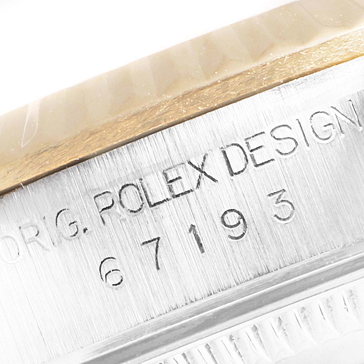 The image shows a close-up of the engraved outer edge of a Rolex Oyster Perpetual 67193 Women
s Steel and Gold (two tone) Champagne Dial 67193 Women
s Steel and Gold (two tone) Champagne Dial model, with the reference number visible.