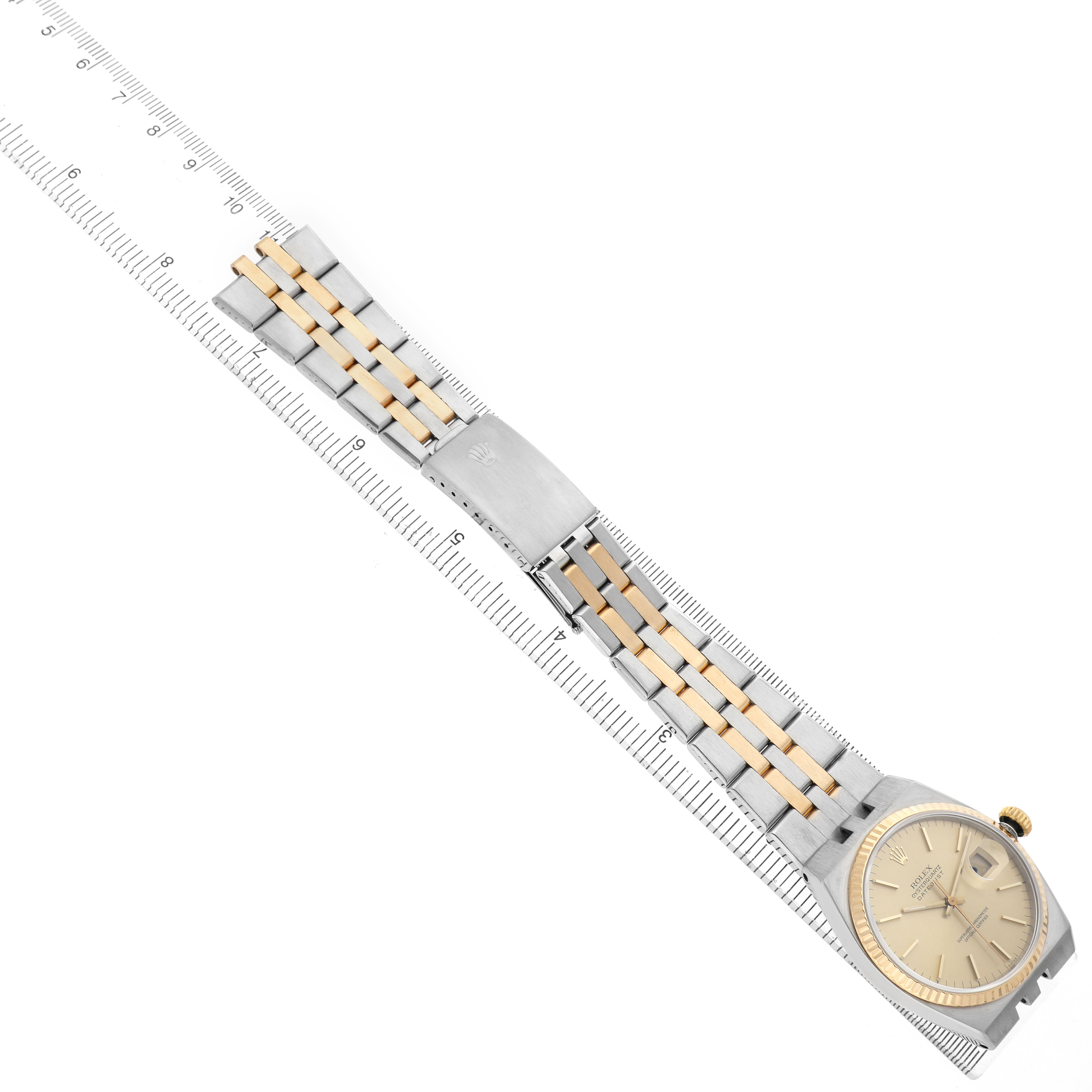 The Rolex Date 17013 Men's Steel and Gold (two tone) Champagne Dial watch is shown from a top view, displaying the bracelet and face aligned with a ruler.
