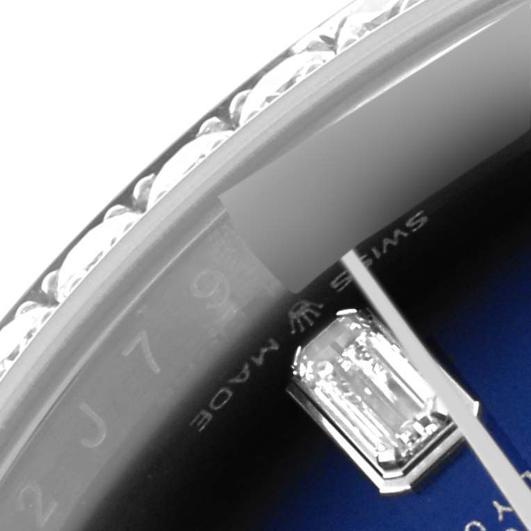 The image shows a close-up of the Rolex President 128349 Men
s White Gold Blue Dial 128349 Men
s White Gold Blue Dial model, focusing on the bezel and a diamond hour marker.