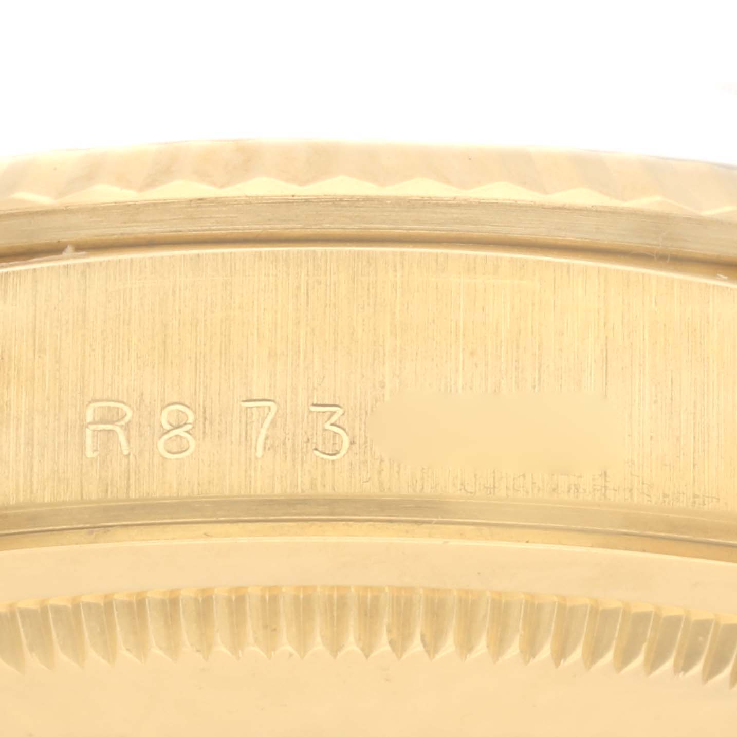 The image shows a close-up of the engraved serial number on the Rolex President 18238 Men's Yellow Gold Champagne Dial 18238 Men's Yellow Gold Champagne Dial watch's bezel.