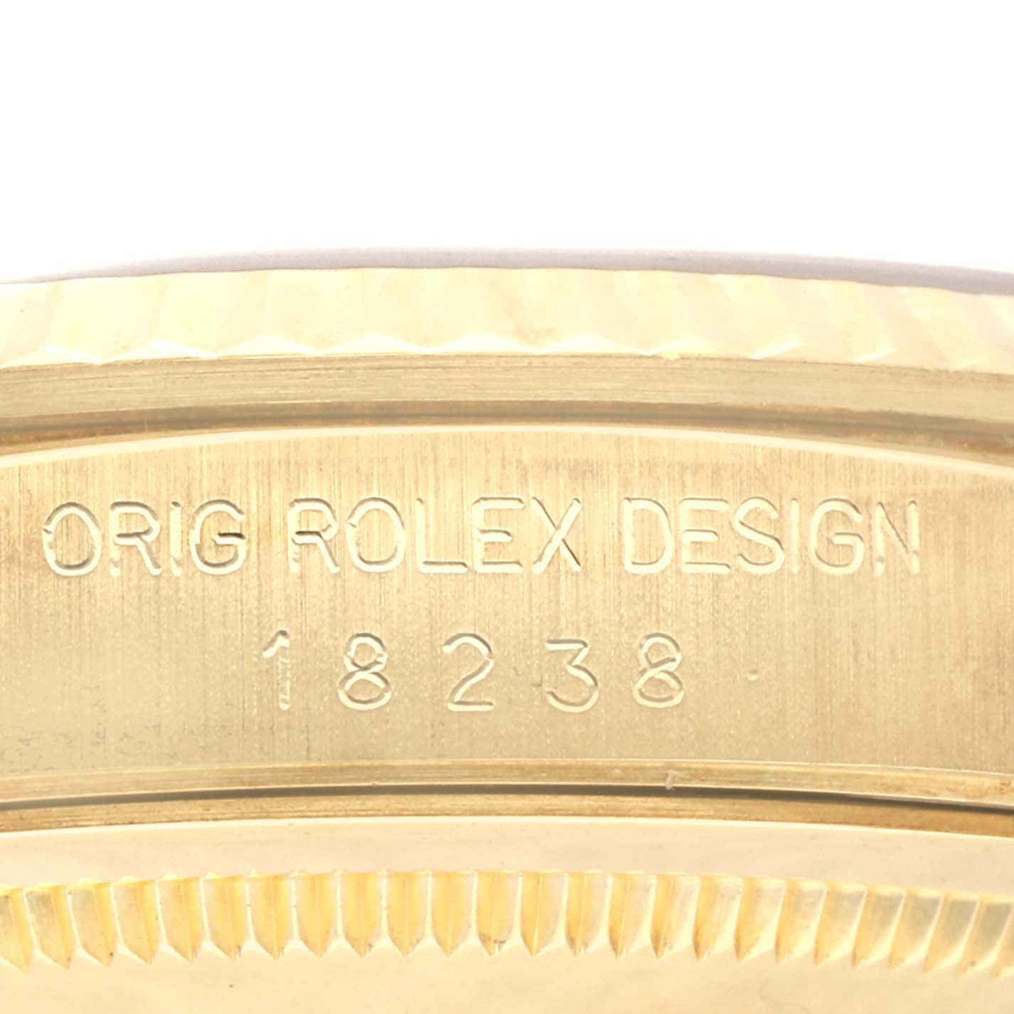 The image shows the side engraving on the case of a Rolex President 18238 Men
s Yellow Gold Champagne Dial 18238 Men
s Yellow Gold Champagne Dial model, displaying "ORIG ROLEX DESIGN" and "18238".