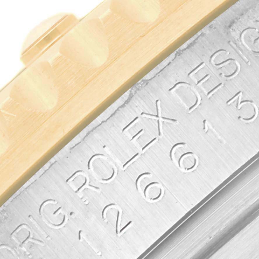 The image shows a close-up of the Rolex Submariner 126613 Men's Steel and Gold (two tone) Blue Dial 126613 Men's Steel and Gold (two tone) Blue Dial's bezel edge with engraved text on the case side.