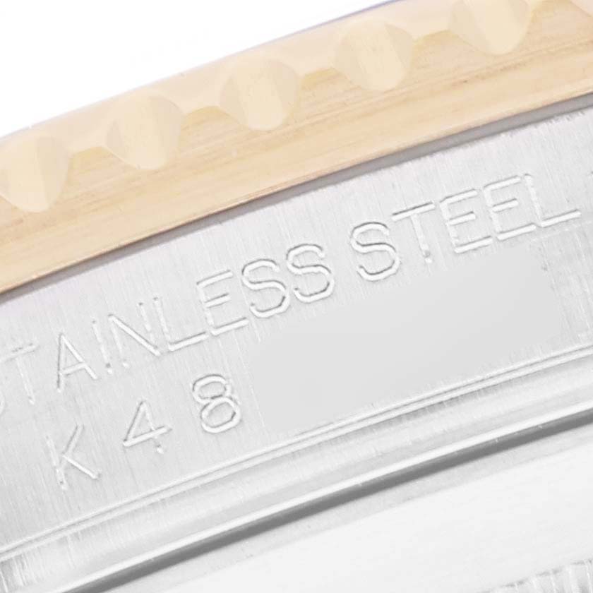 This close-up angle of the Rolex Submariner 16613 Men's Steel and Gold (two tone) Blue Dial 16613 Men's Steel and Gold (two tone) Blue Dial shows a portion of its stainless steel case with engraved text.