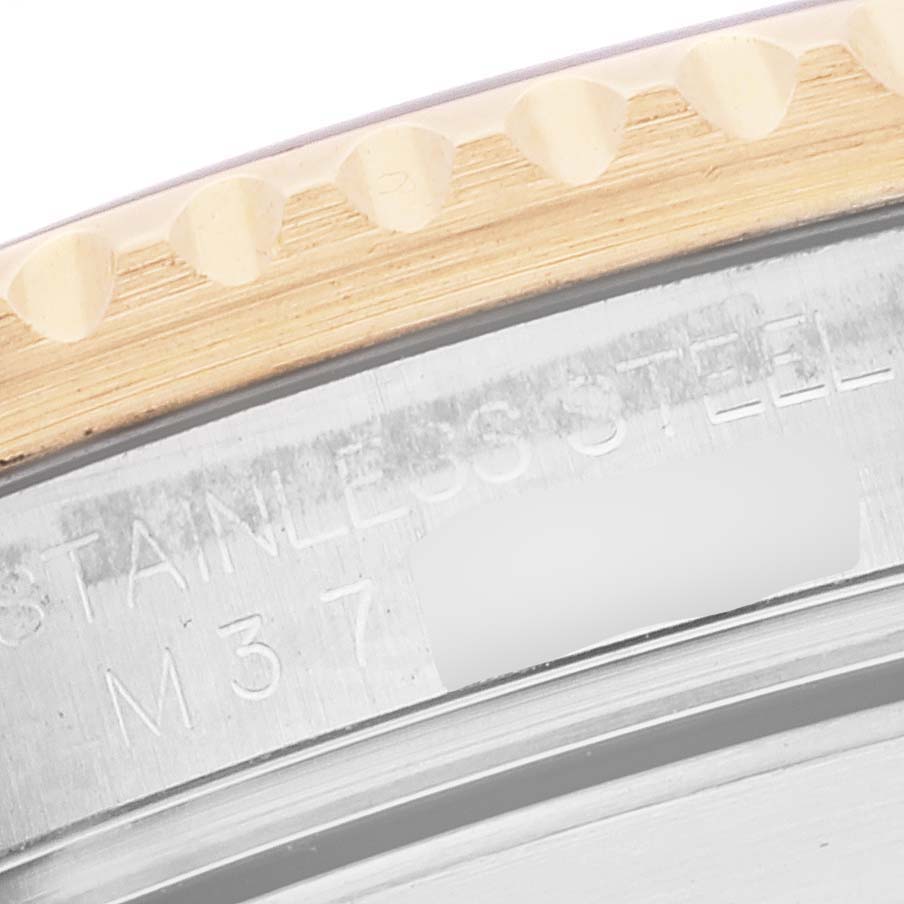This image shows a close-up of the case edge and part of the bezel of a Rolex Submariner 16613 Men's Steel and Gold (two tone) Black Dial 16613 Men's Steel and Gold (two tone) Black Dial watch, with "STAINLESS STEEL" engraved.